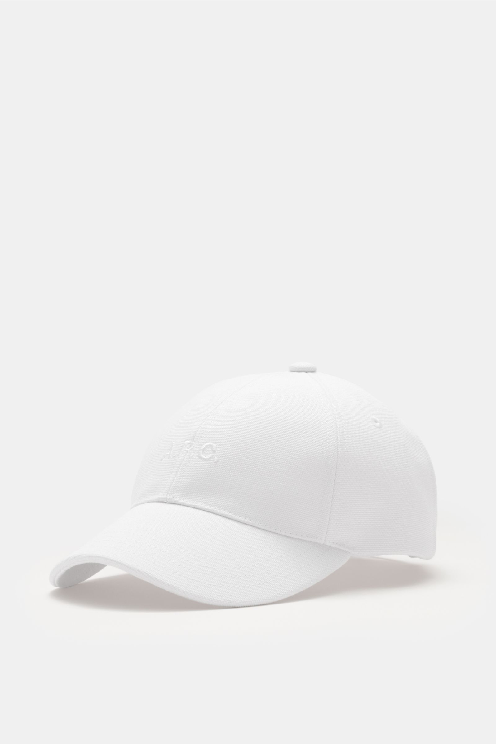 A.P.C. Baseball-Cap 'Charlie' weiß aus robustem Baumwoll-Canvas, Six-Panel-Design mit tonalem Logo-Stitching, verstellbar, seitliche Nahaufnahme.