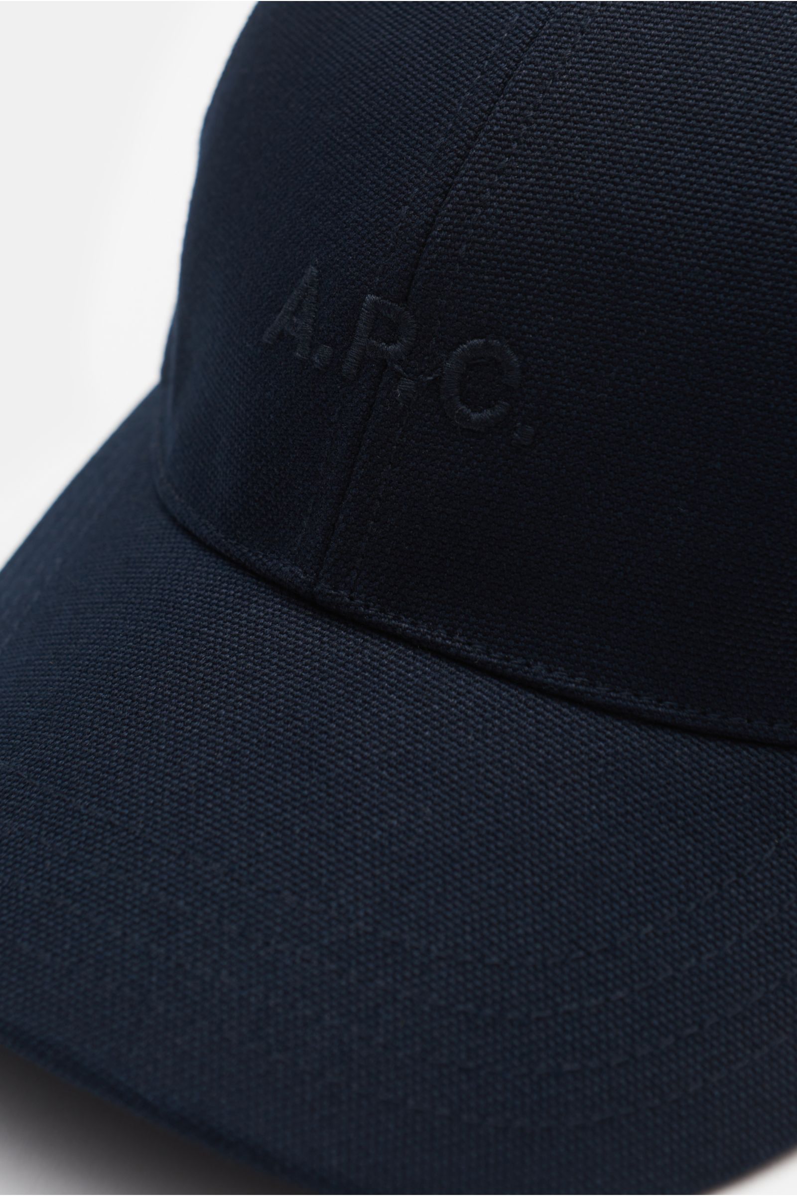Nahaufnahme der A.P.C. Baseball-Cap 'Charlie' navy aus robustem Baumwoll-Canvas, Six-Panel-Design mit tonalem Logo-Stitching vorne.