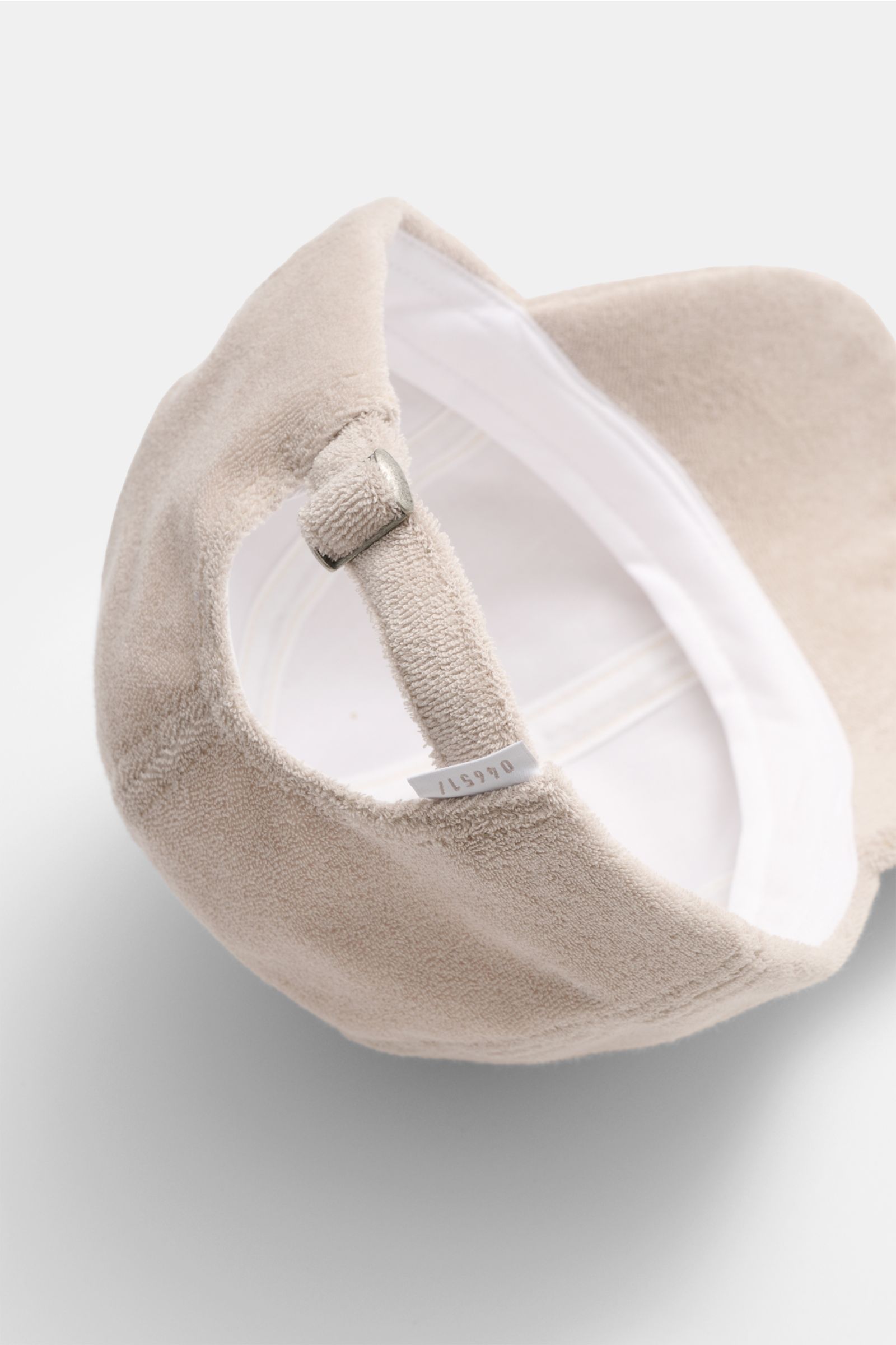 Close-up rear interior view of the 04651/ A trip in a bag Terry baseball cap 'Terry' beige in soft cotton terry with adjustable closure.

Spring awakening: This stylish baseball cap in soft terry from the label 04651/ A TRIP IN A BAG offers good protectio