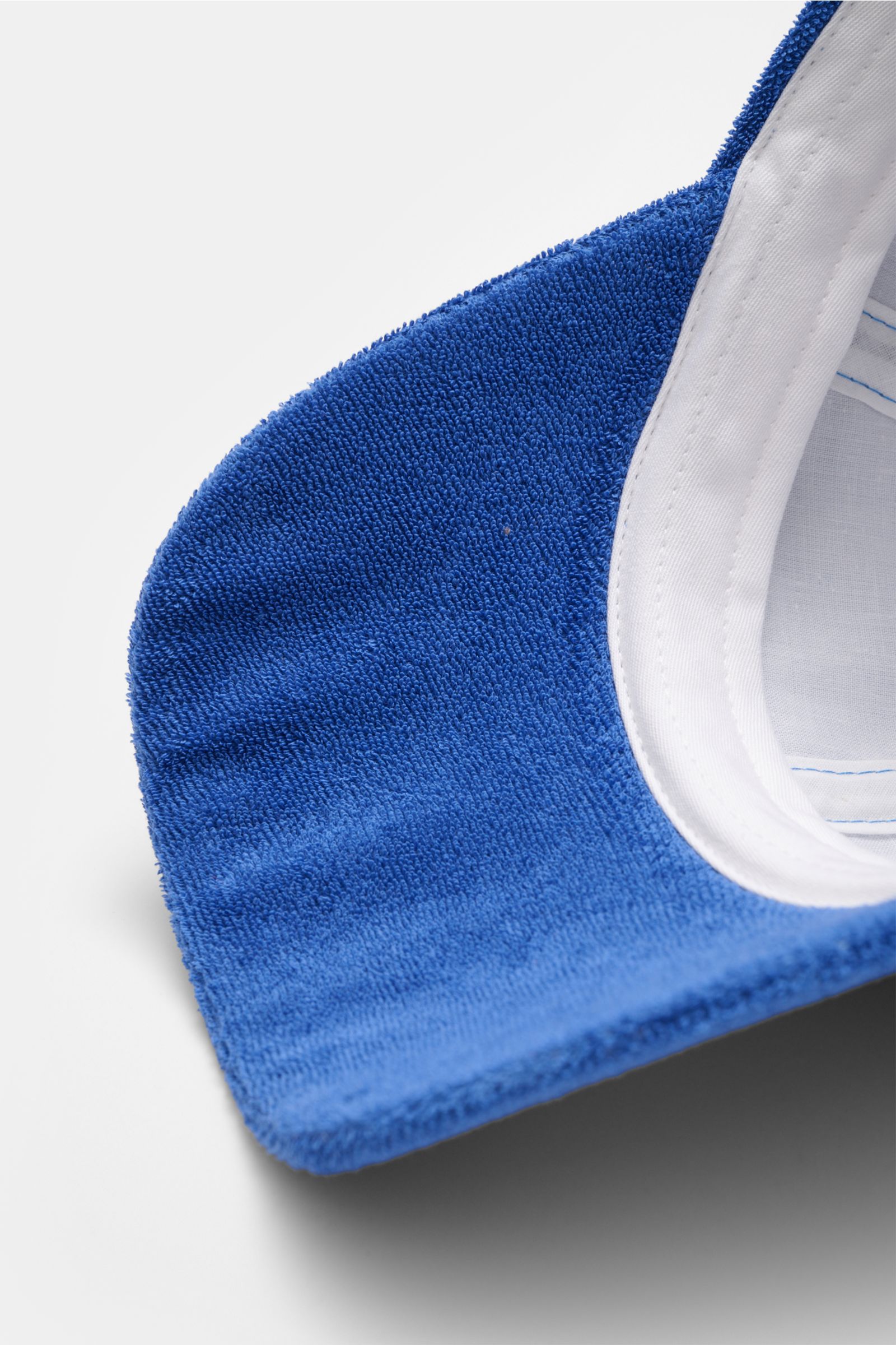 Close-up top-down view of the blue cotton terry fabric and white inner band of the 04651/ A trip in a bag Terry baseball cap 'Terry' blue, featuring a soft feel, six-panel style, and adjustable closure. Spring awakening: This stylish baseball cap in soft 