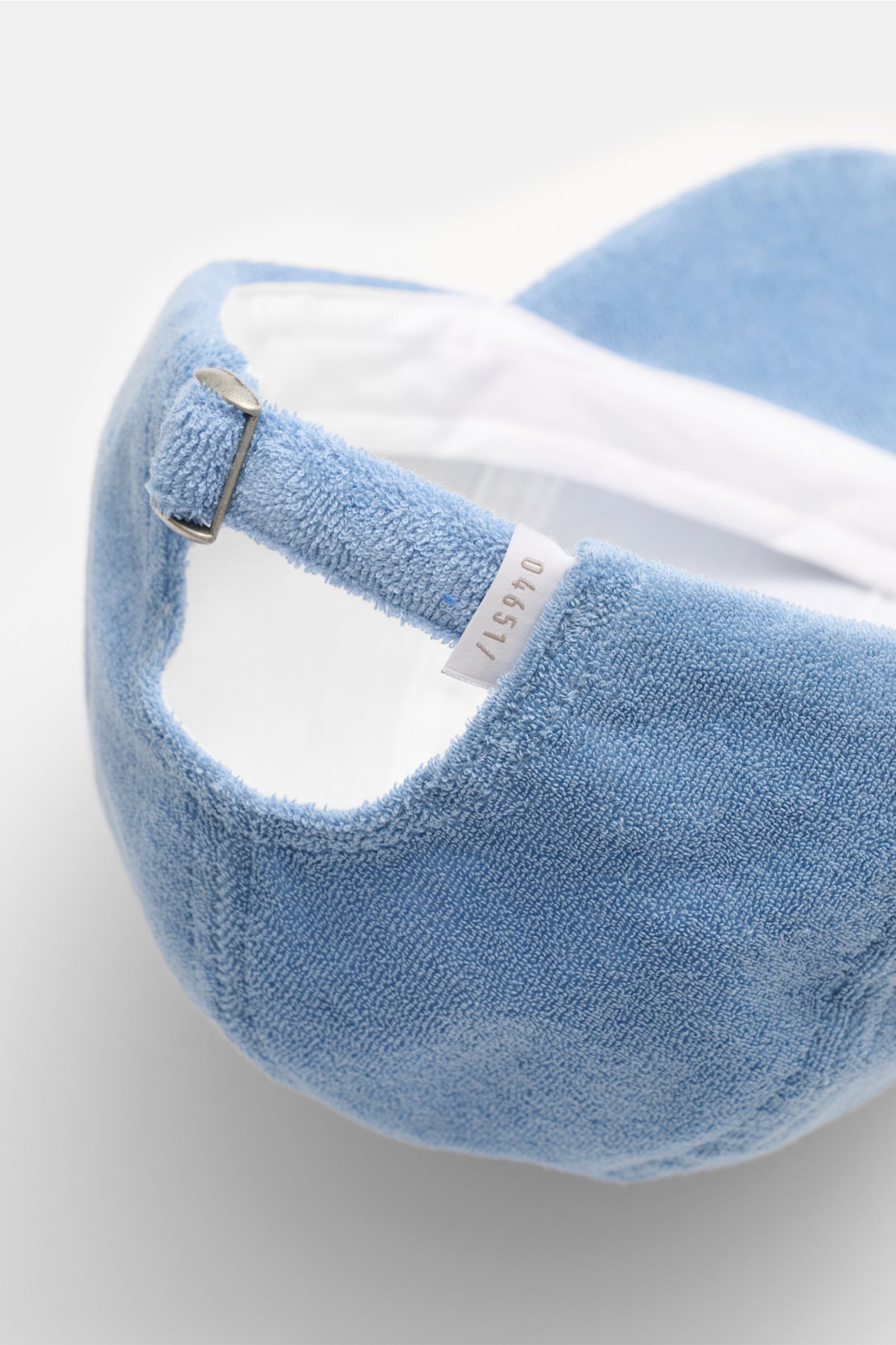 Close-up rear view of the 04651/ A trip in a bag Terry baseball cap 'Terry' smoky blue in soft cotton terry with adjustable metal closure.

Description: Spring awakening: This stylish baseball cap in soft terry from the label 04651/ A TRIP IN A BAG off