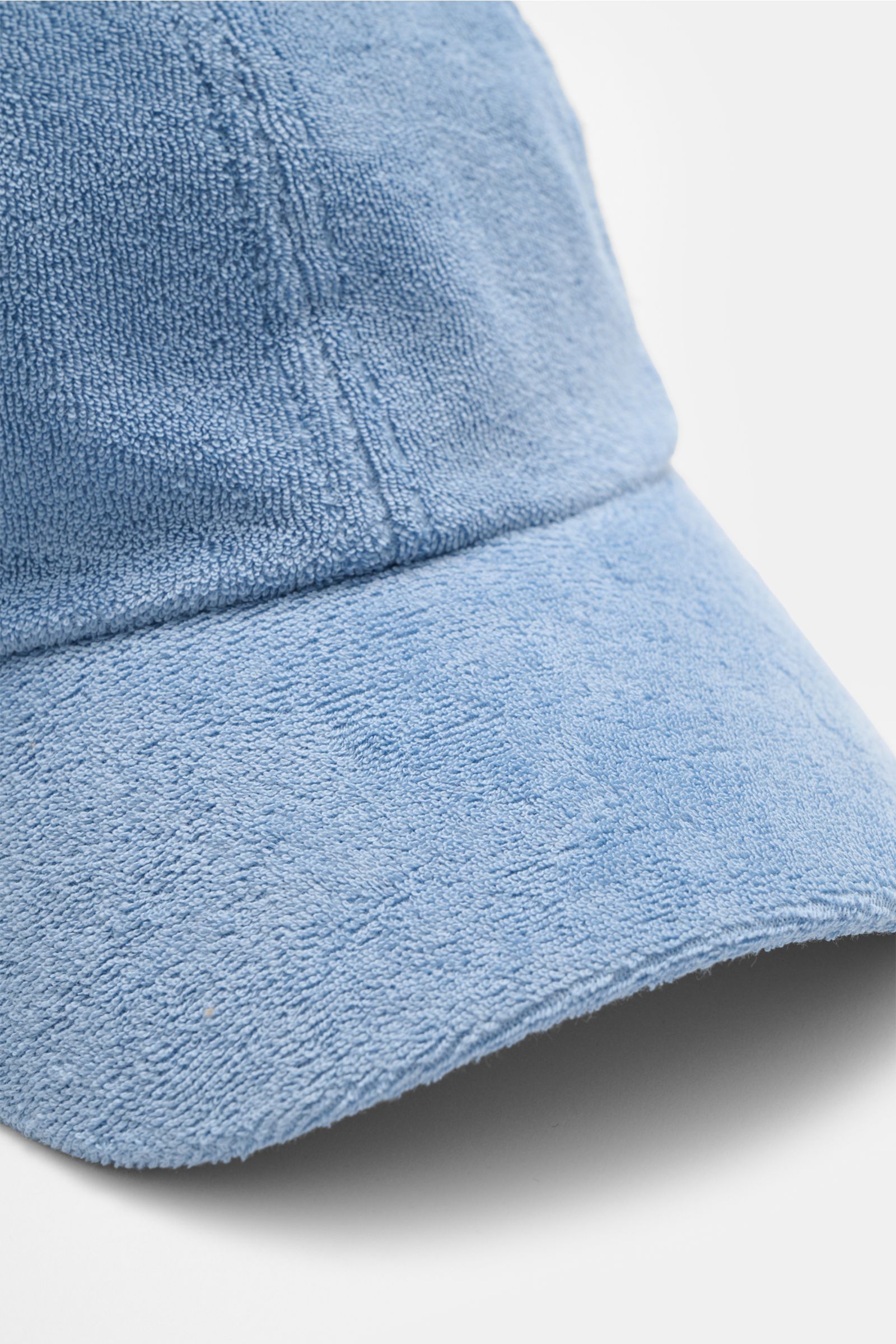 Close-up front-side view of the 04651/ A trip in a bag Terry baseball cap 'Terry' smoky blue in soft cotton terry fabric, showing texture and stitching. Spring awakening: This stylish baseball cap in soft terry from the label 04651/ A TRIP IN A BAG offers
