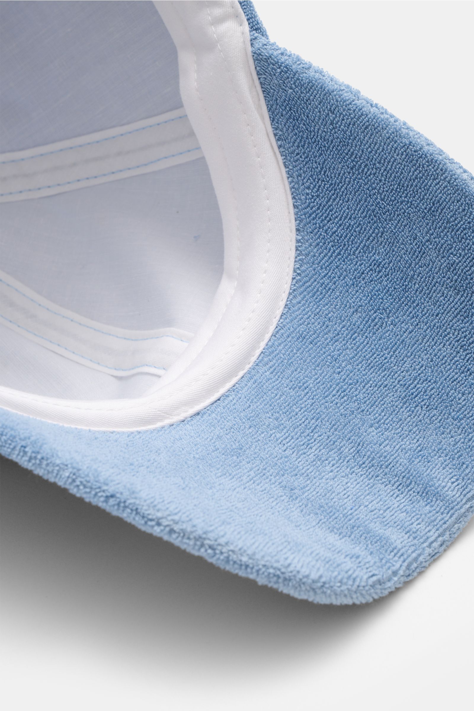 Close-up top-down view of the 04651/ A trip in a bag Terry baseball cap 'Terry' smoky blue, showing soft cotton terry fabric and white inner band. Spring awakening: This stylish baseball cap in soft terry from the label 04651/ A TRIP IN A BAG offers good 