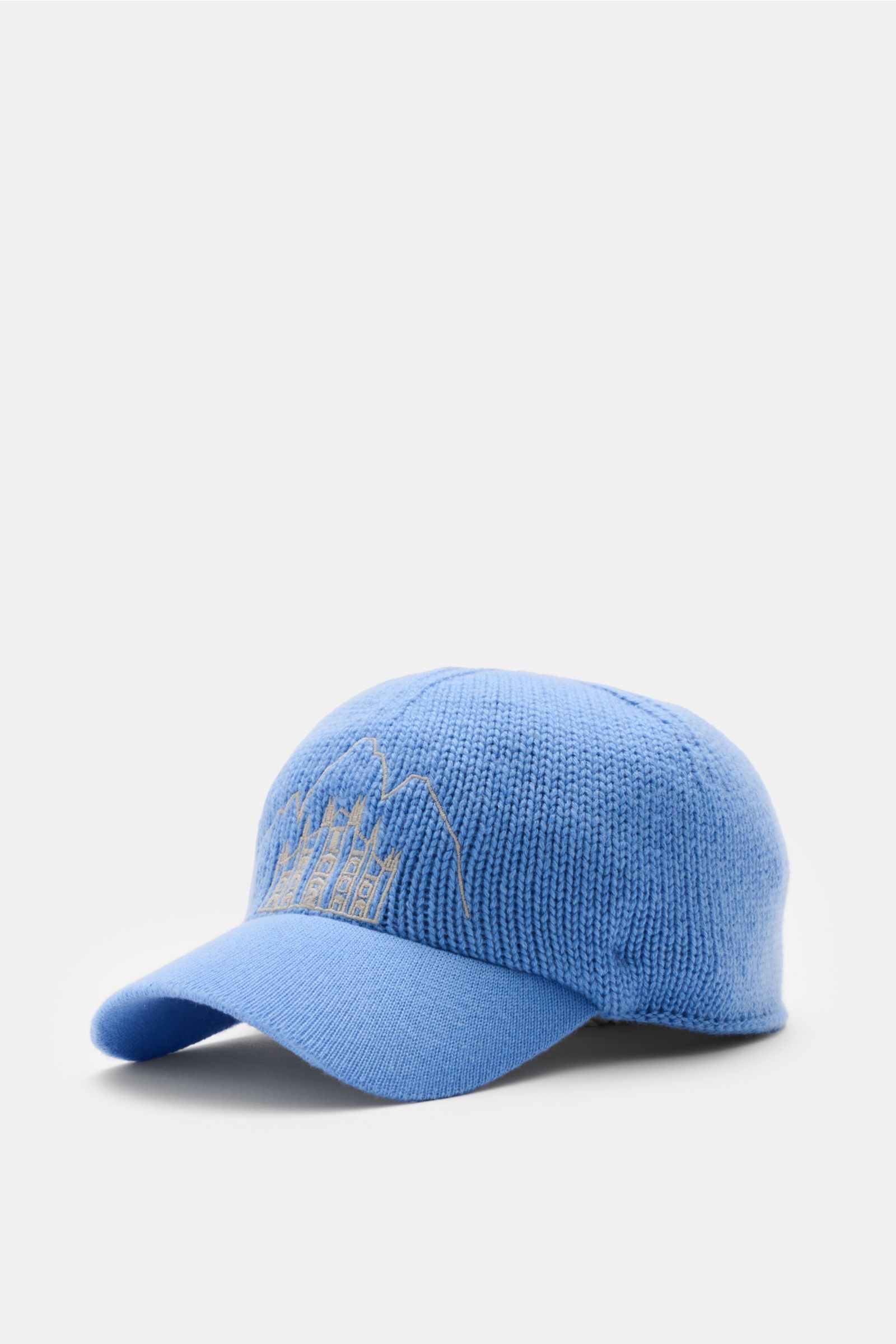 04651/ A trip in a bag Cashmere Baseball-Cap blau, seitliche Perspektive, feiner Strick, weicher Griff, mittelgrobes Strickbild, Schirm in Feinstrick, Stitching von Mailänder Dom und Cortina-Bergspitzen.