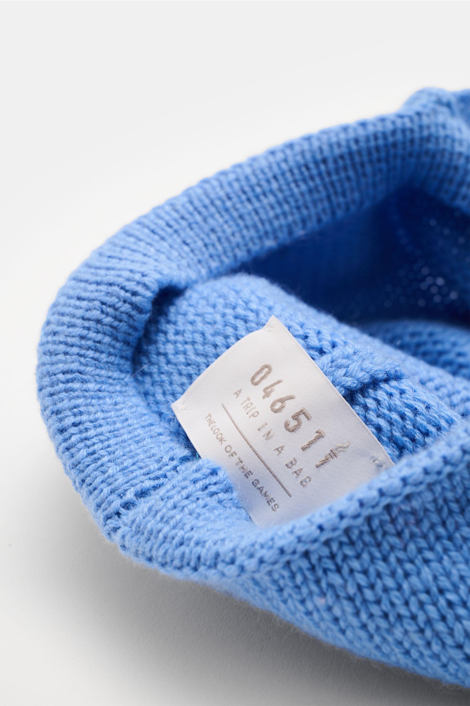 04651/ A trip in a bag Cashmere Baseball-Cap blau, Nahaufnahme von innen, feiner, weicher Cashmere-Strick mit Etikett und mittlerem Strickbild.