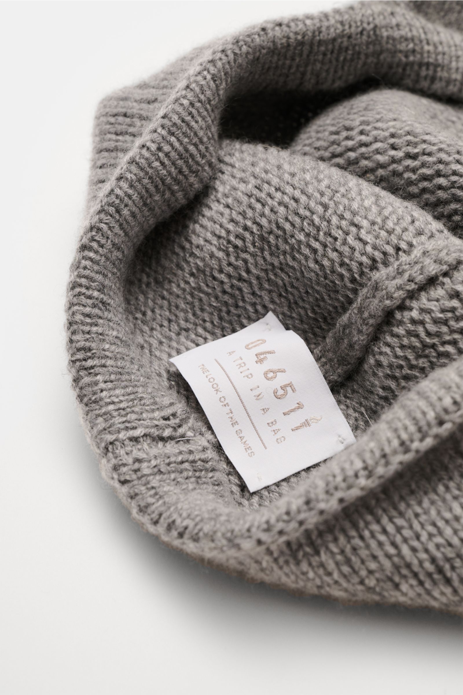04651/ A trip in a bag Cashmere Baseball-Cap grau meliert, Detailaufnahme von innen mit feinem Strick und Label, reiner Cashmere, weicher Griff.