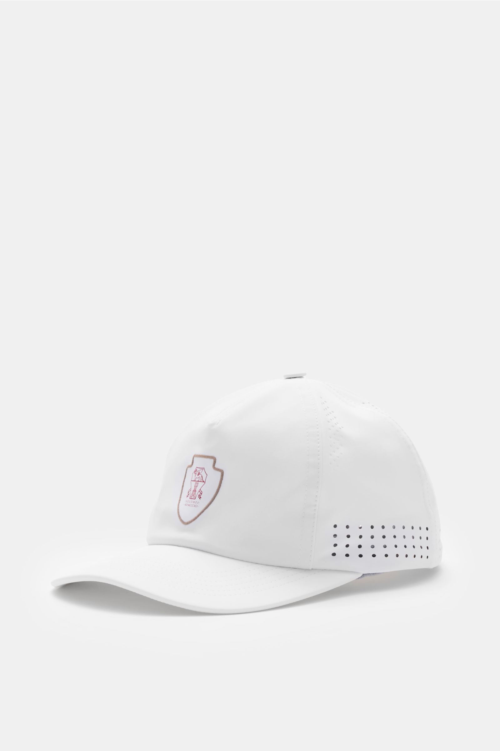 Brunello Cucinelli Baseball-Cap weiß shown from a front-side angle, featuring Solomeo-logo, perforations, and adjustable strap.