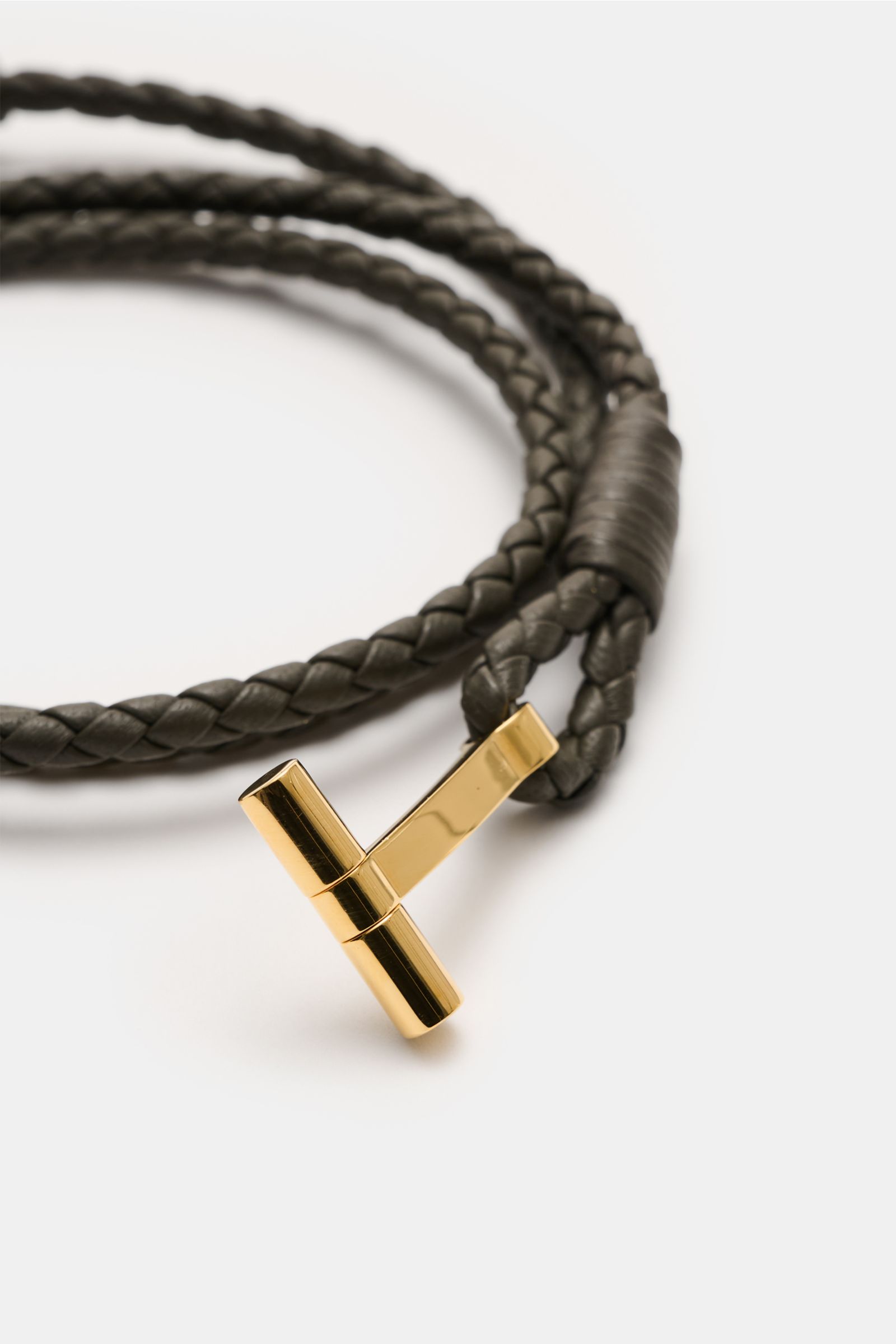 Close-up front view of Tom Ford Armband dunkelbraun/gold with braided dark brown leather strap and gold T-shaped clasp.

Wählen Sie mit dem schmalen Lederarmband aus geflochtenem Leder und mit goldfarbenem T-Verschluss von Luxus-Designer TOM FORD ein d