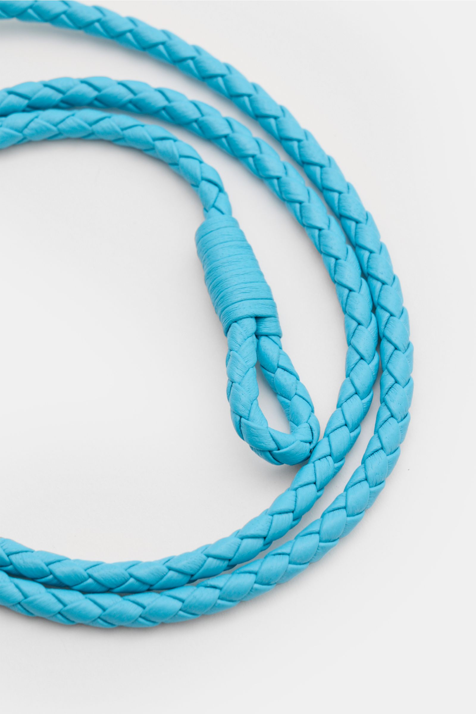 Close-up top view of Tom Ford Armband azurblau/silber with braided smooth azure blue leather, loop closure, and gold-tone T clasp.

Description: Wählen Sie mit dem schmalen Lederarmband aus geflochtenem Leder und mit goldfarbenem T-Verschluss von Luxus