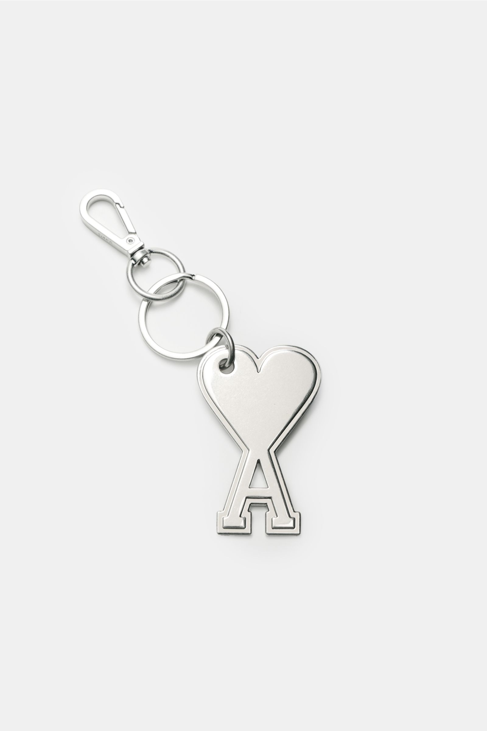 Top-down view of Ami Paris Schlüsselanhänger silber, a silver keychain with a heart-shaped 'A' logo charm, keyring, and carabiner.

Unisex Accessoire von AMI PARIS: Dieser praktische Begleiter mit dem markentypischen 'A' mit Herz hält Ihre Schlüssel an