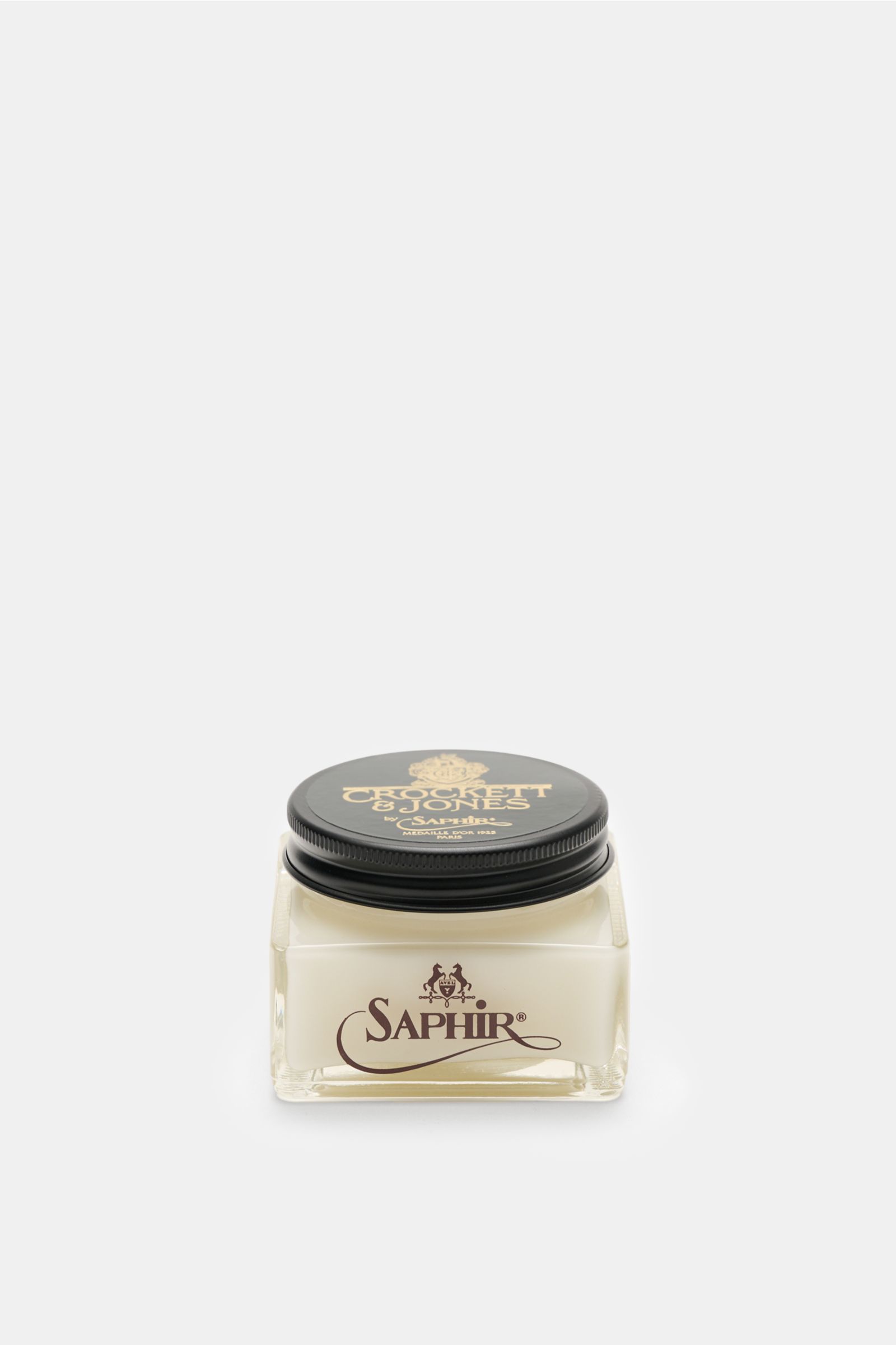 Front-facing view of Crockett & Jones Shoe polish translucent 75 ml in a square glass jar with a black lid, showing the Saphir logo.

A shoe care essential by CROCKETT & JONES: This unique cream shoe polish nourishes, cares and revives the colour of hi