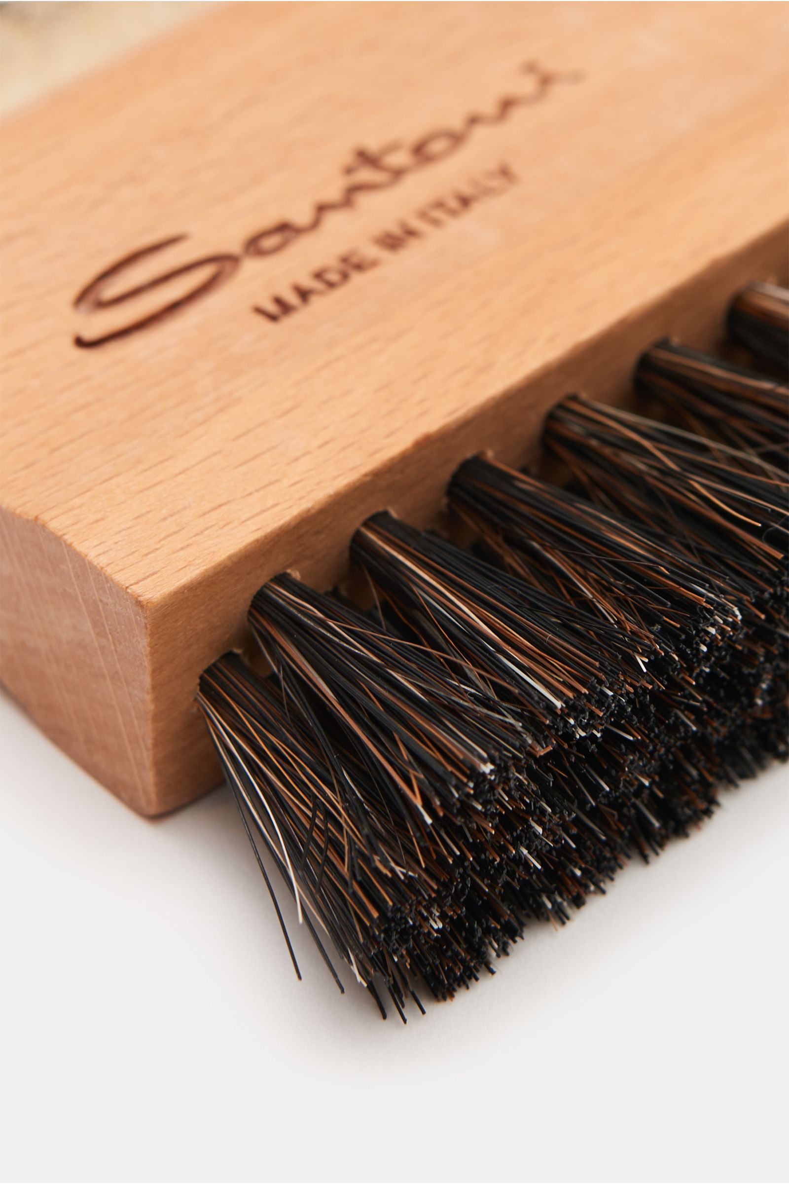 Santoni Polierbürste aus Holz mit SANTONI-Logo, Borsten aus Rosshaarmischung und Gummiseite, Nahaufnahme von schräg oben, Made in Italy.