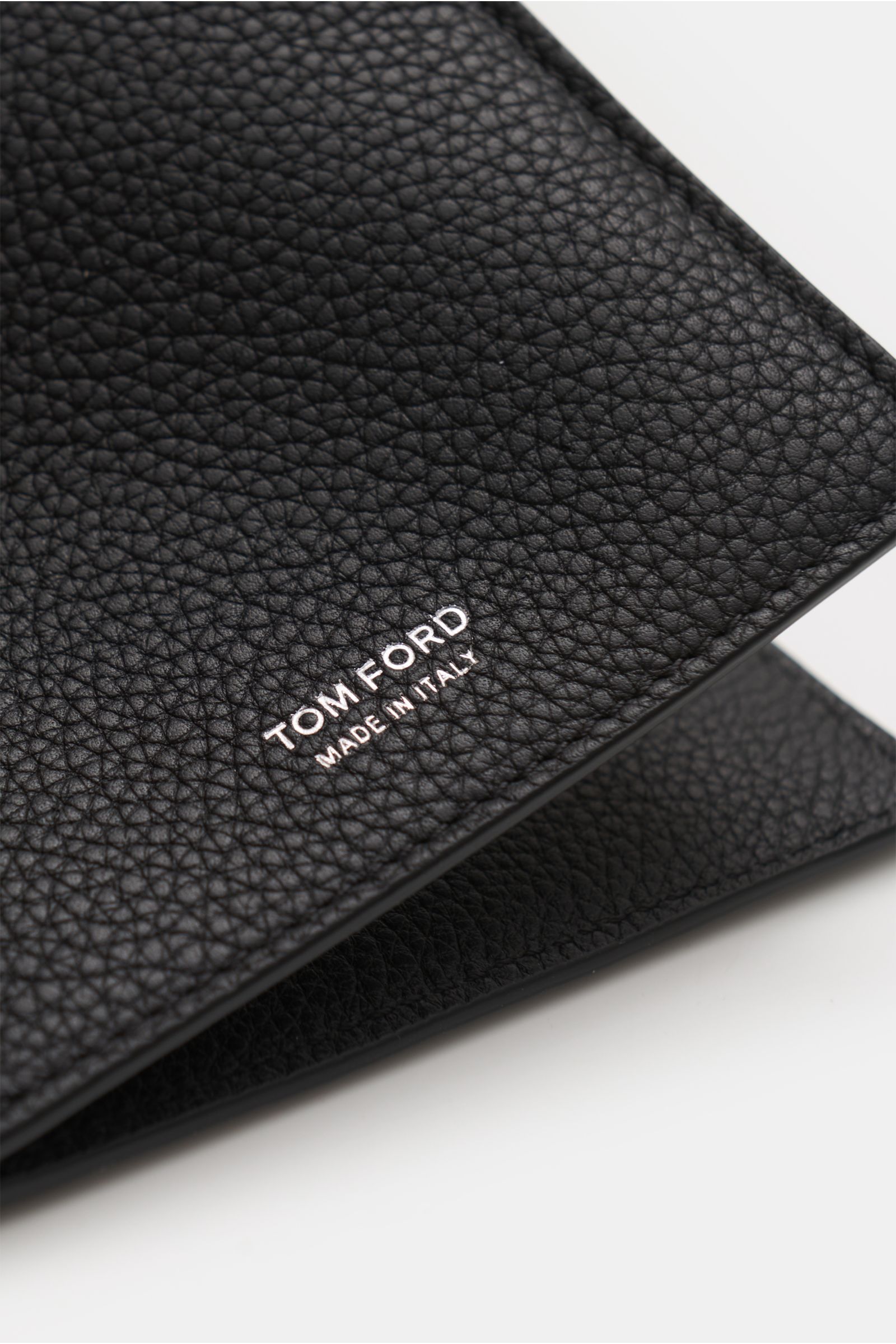 Close-up angled view of the Tom Ford Credit card holder black, showing grained calfskin texture and silver TOM FORD embossing.

This practical case in fine calfskin and with high-quality brass hardware by TOM FORD embodies the luxury status of a stylis