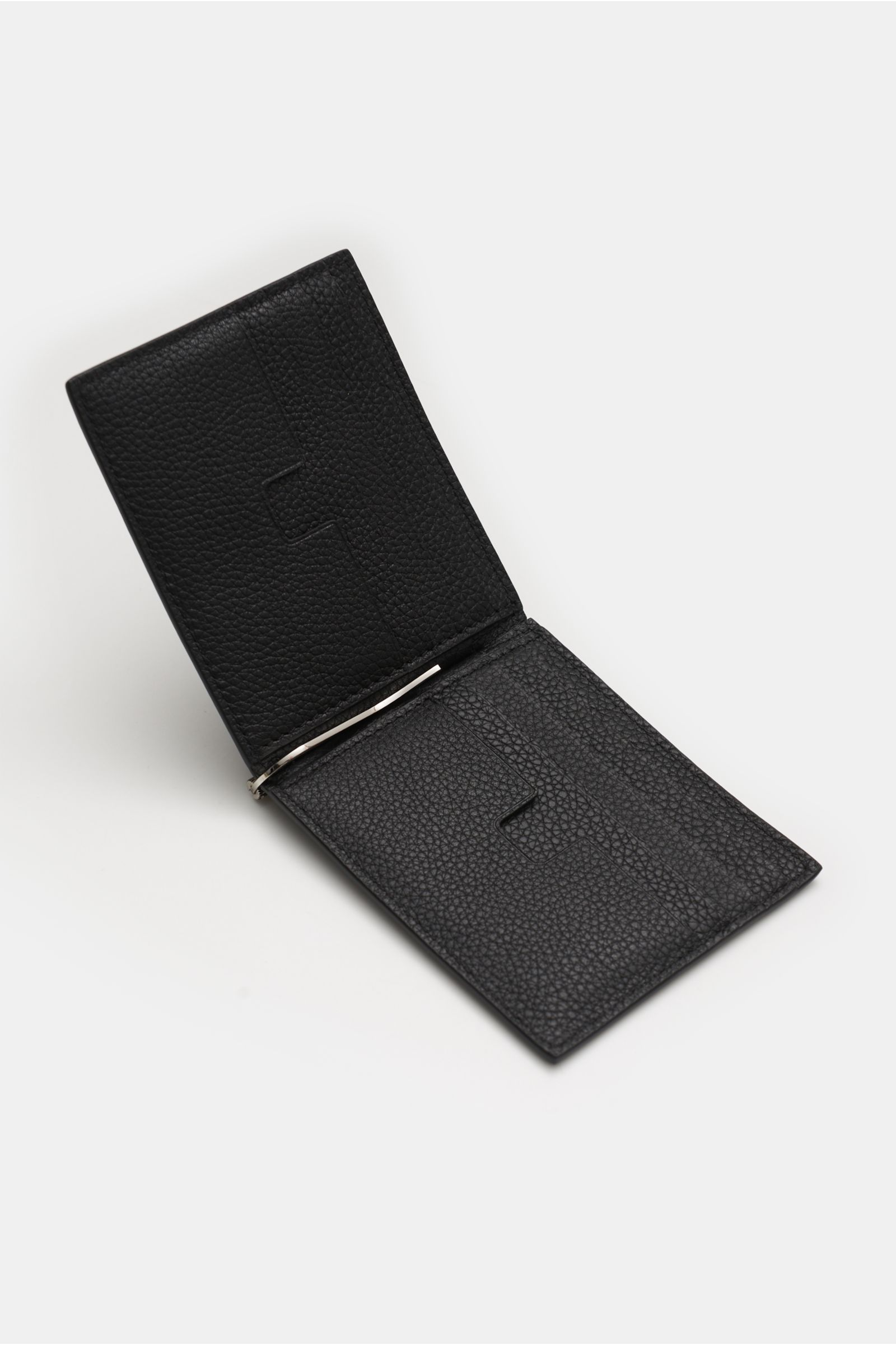 Open black Tom Ford Credit card holder photographed from a high angle, showing its grained calfskin texture and cash clip.

This practical case in fine calfskin and with high-quality brass hardware by TOM FORD embodies the luxury status of a stylish ac