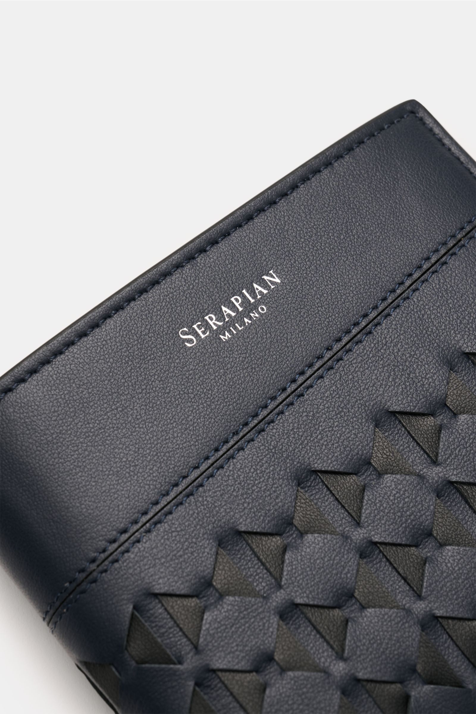 Serapian Portemonnaie 'Mosaico' navy/schwarz aus edlem Glattleder mit feiner Narbung, silberfarbener Prägung, Mosaico-Design, Nahaufnahme schräg von oben.
