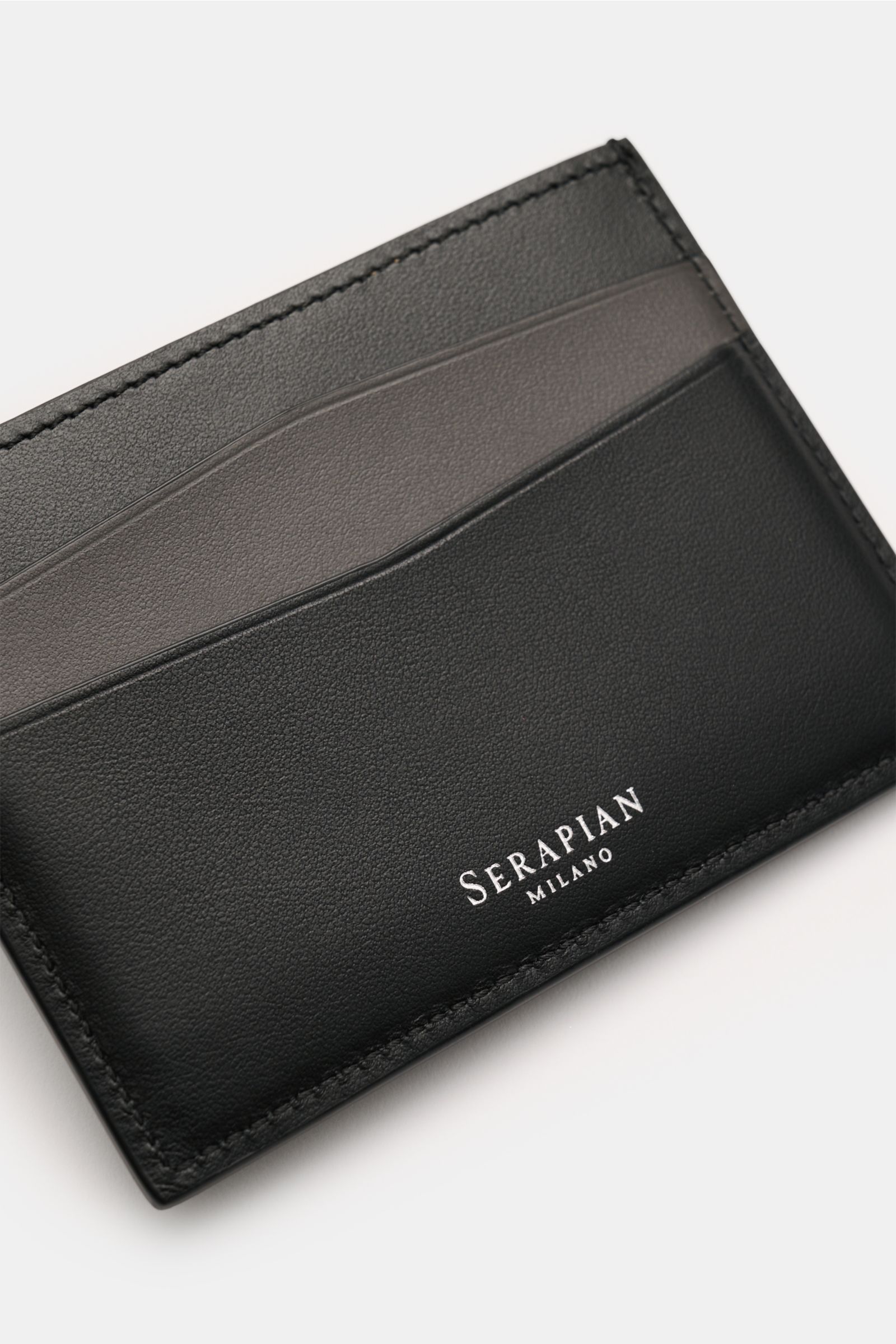 Serapian Kartenetui 'Mosaico' schwarz/dunkelgrau, handgearbeitet, edles Glattleder mit feiner Narbung, Mosaico-Design, silbernes Logo, Ansicht von oben schräg.