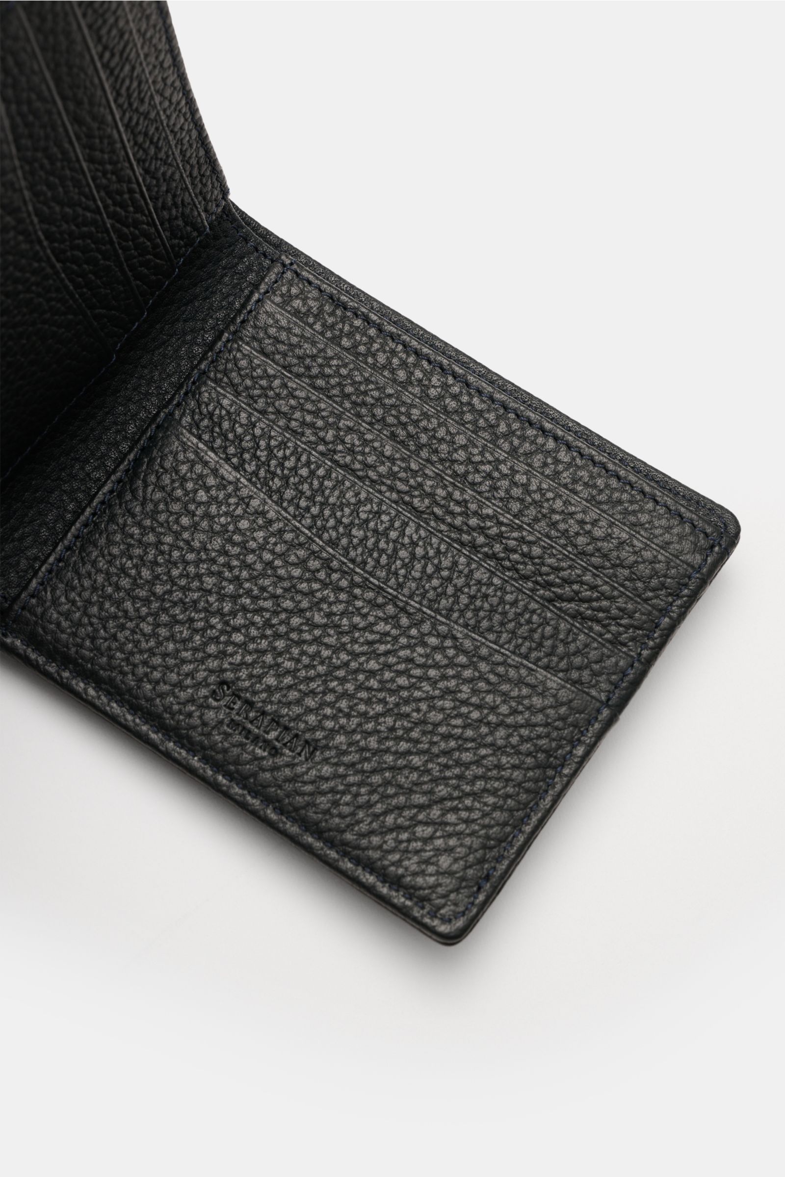 Opened Serapian Portemonnaie navy in textured cashmere calf leather, showing eight card slots and embossed logo from top-down angle.

Description: Alles Wesentliche stilvoll organisiert: Das klassische Portemonnaie von SERAPIAN aus edlem Cashmere-Leder