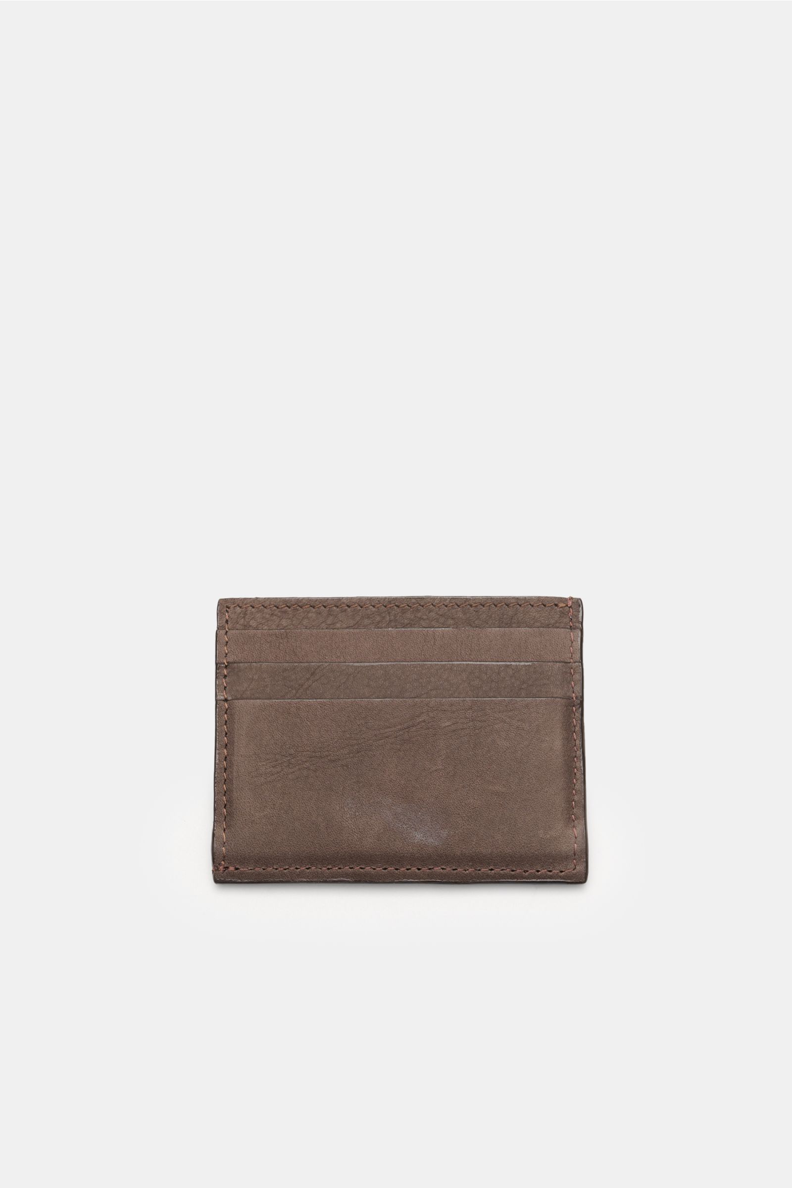 Front view of the 04651/ A trip in a bag Kartenetui dunkelbraun, a flat, minimalist cardholder made of dark brown nubuck leather with six card slots, a main compartment, and 04651/-embossing, measuring approximately 10 x 8 cm.

Description: 
Minimalist