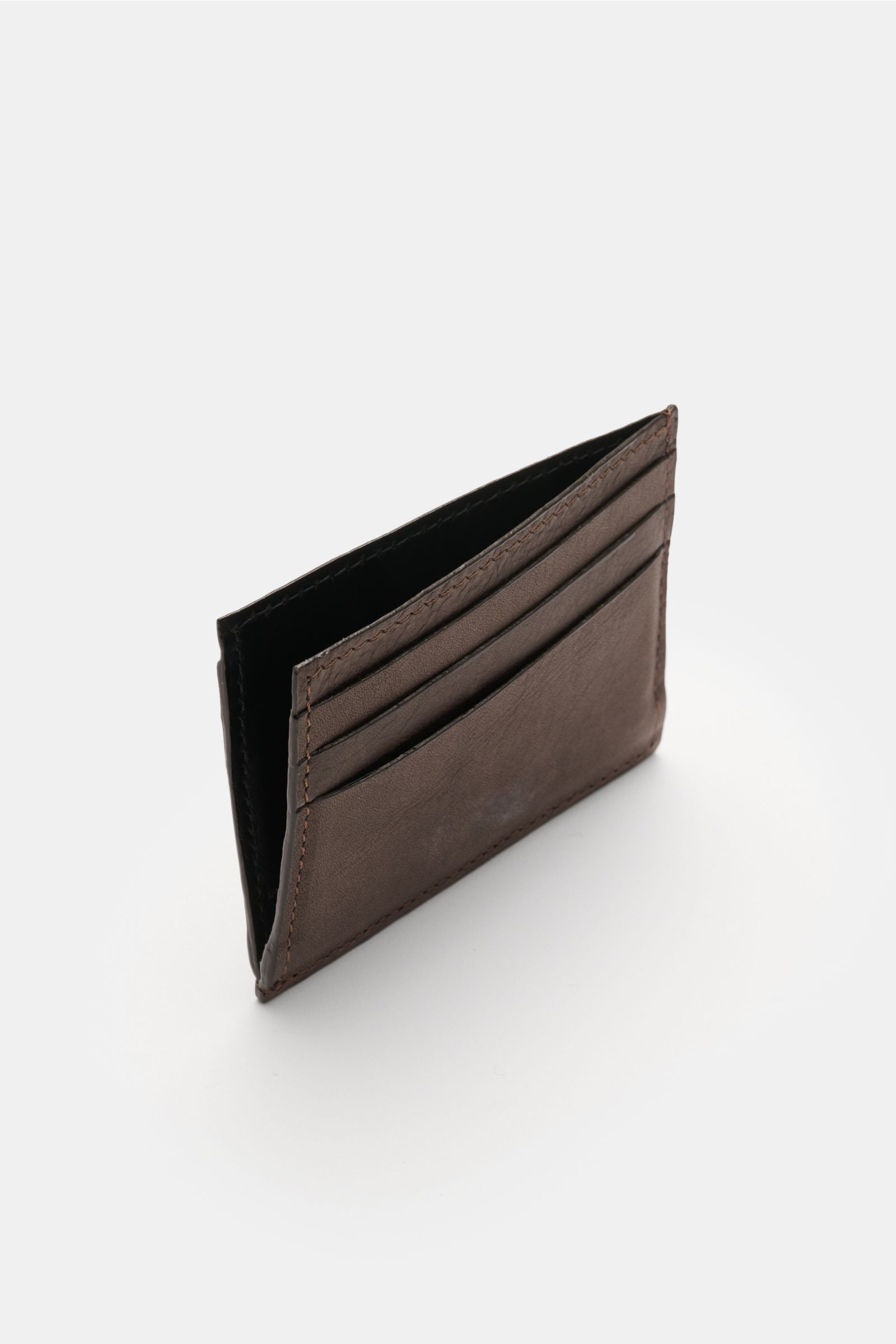 Side angled view of the 04651/ A trip in a bag Kartenetui dunkelbraun, a flat dark brown nubuck leather cardholder with six card slots and a main compartment, measuring approx. 10 x 8 cm, featuring 04651/- embossing.

Description: 
Minimalistisches All