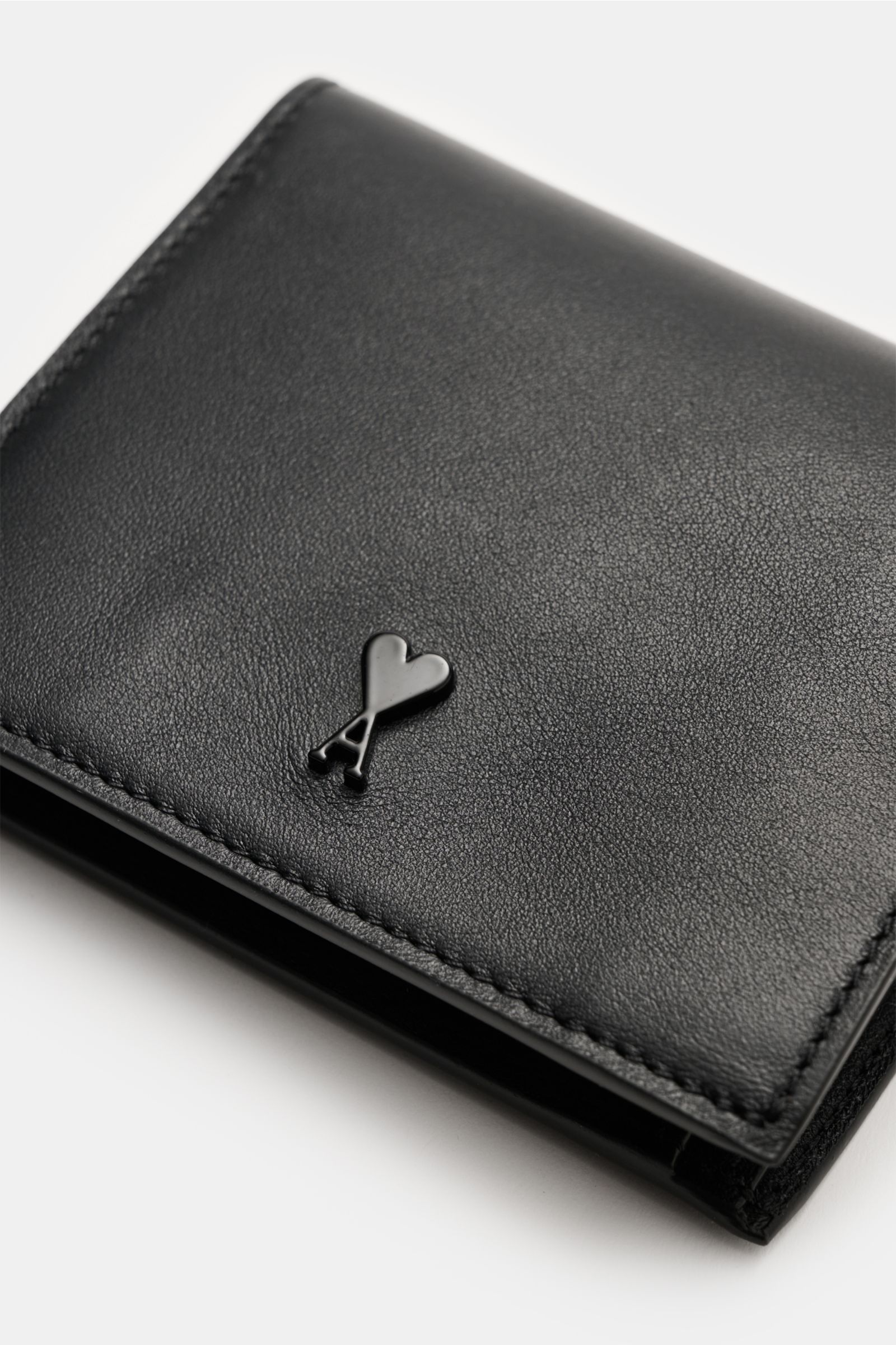 Ami Paris Portemonnaie schwarz aus fein genarbtem Kalbleder, Frontlogo, vier Kartenfächer, Münzfach mit Druckknopf, Seitenperspektive.