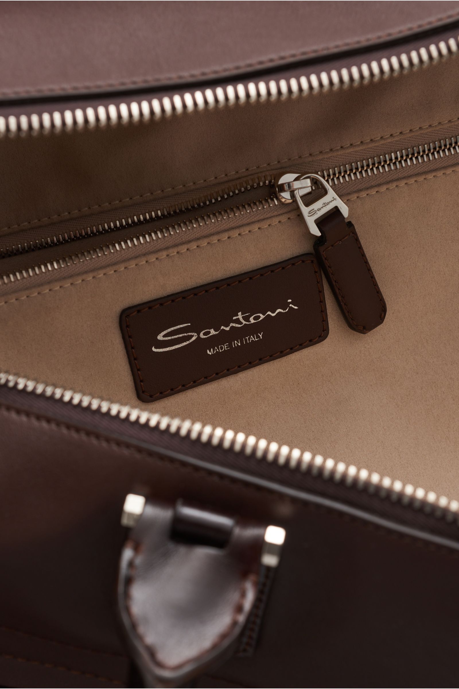 Santoni Weekender braun, Innenansicht mit softem, genarbtem Glattleder, silberfarbener Reißverschluss, Logo-Prägung und Textilfutter, geräumig.