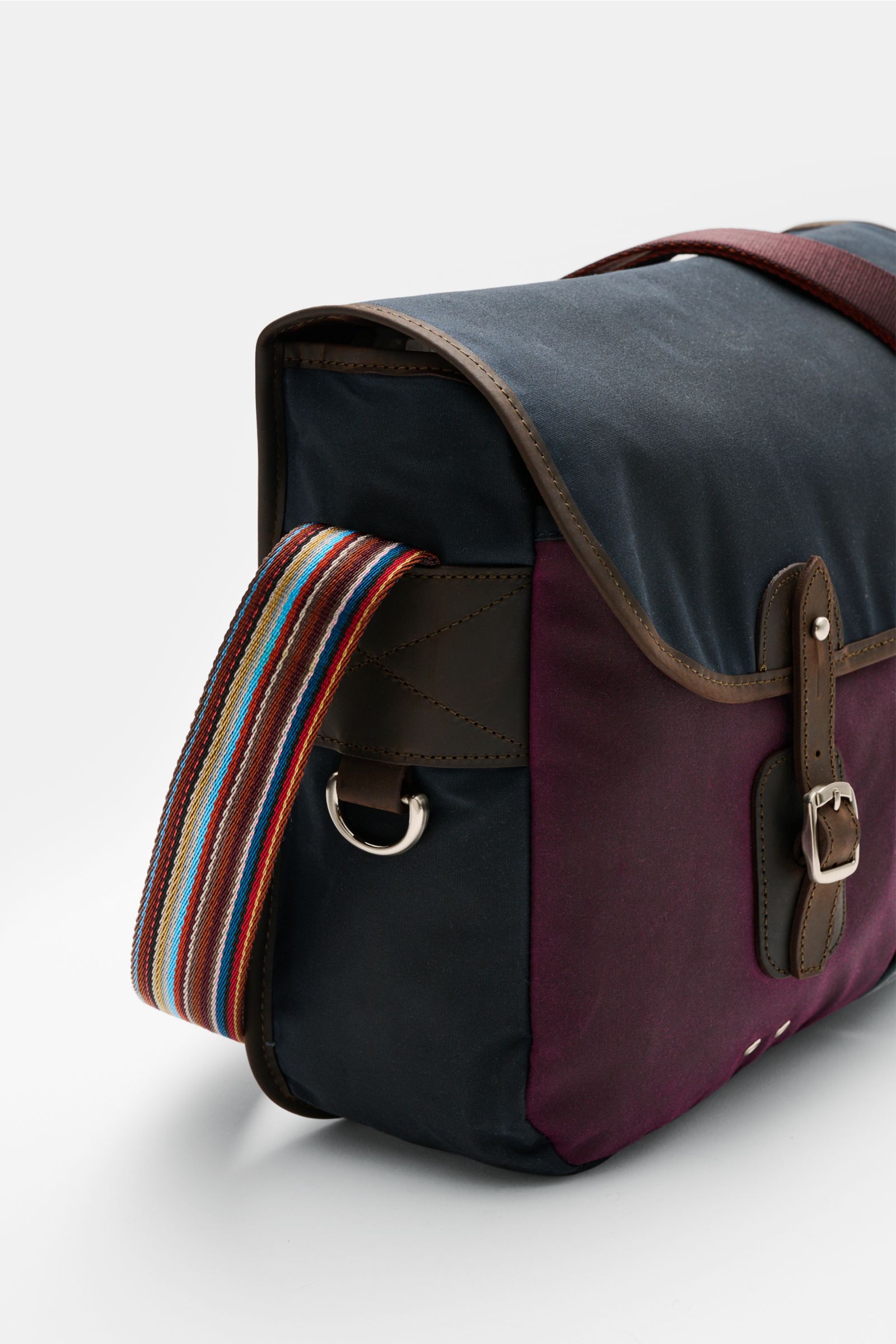 Barbour Umhängetasche 'Tarras' navy/bordeaux/petrol, seitliche Nahaufnahme, gewachste Baumwolle, Lederdetails, bunter Schultergurt, silberfarbene Hardware.