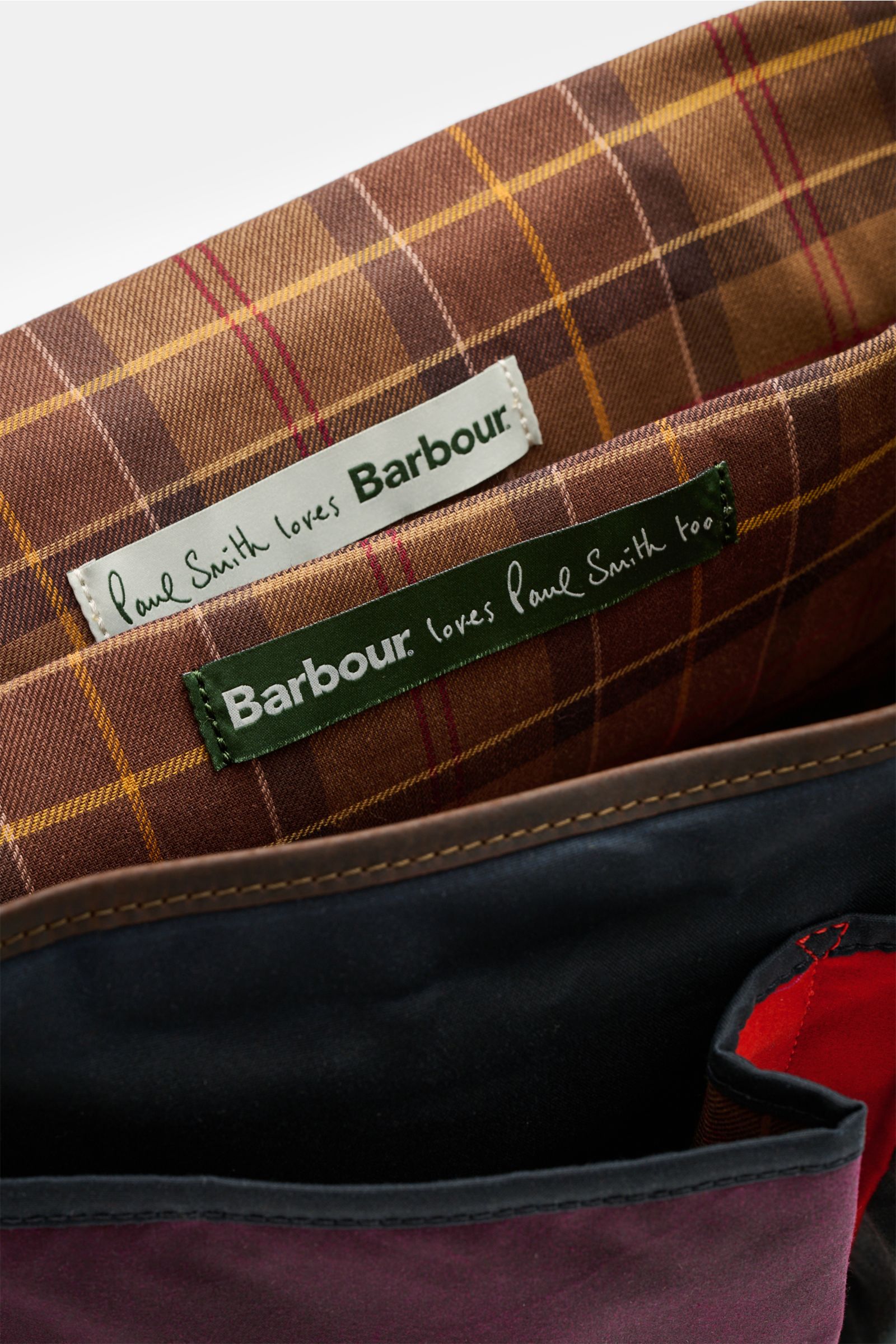 Barbour Umhängetasche 'Tarras' navy/bordeaux/petrol von oben fotografiert, gewachste Baumwolle, Innenfutter kariert, zwei Labels, robust.