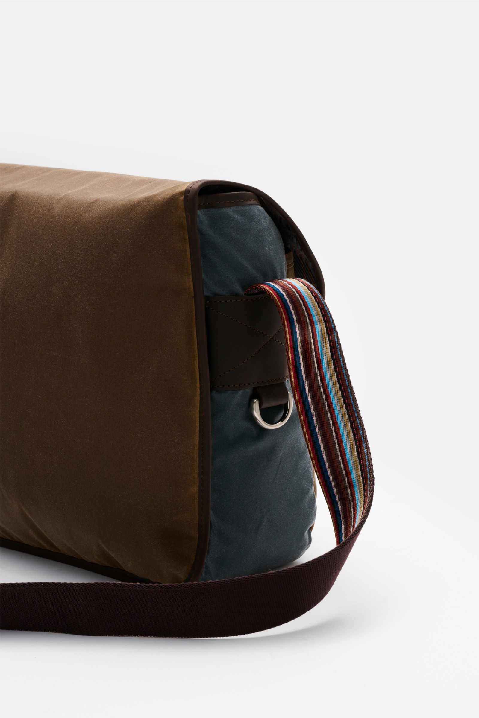 Seitliche Nahaufnahme der Barbour Umhängetasche 'Tarras' braun/petrol aus gewachster Baumwolle mit robustem Schultergurt und silberfarbener Hardware.