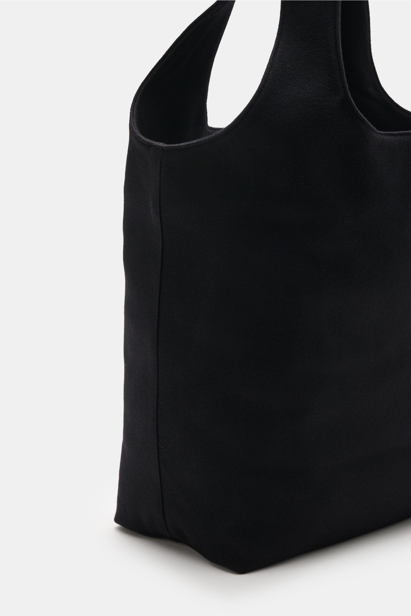 A.P.C. Shopper 'Ninon' schwarz shown from a side angle, made of a mix of wool, microfiber, and cashmere, featuring wide handles, a spacious main compartment, one slip pocket, front with logo print, dimensions approx. 48 cm x 36 cm x 17 cm.