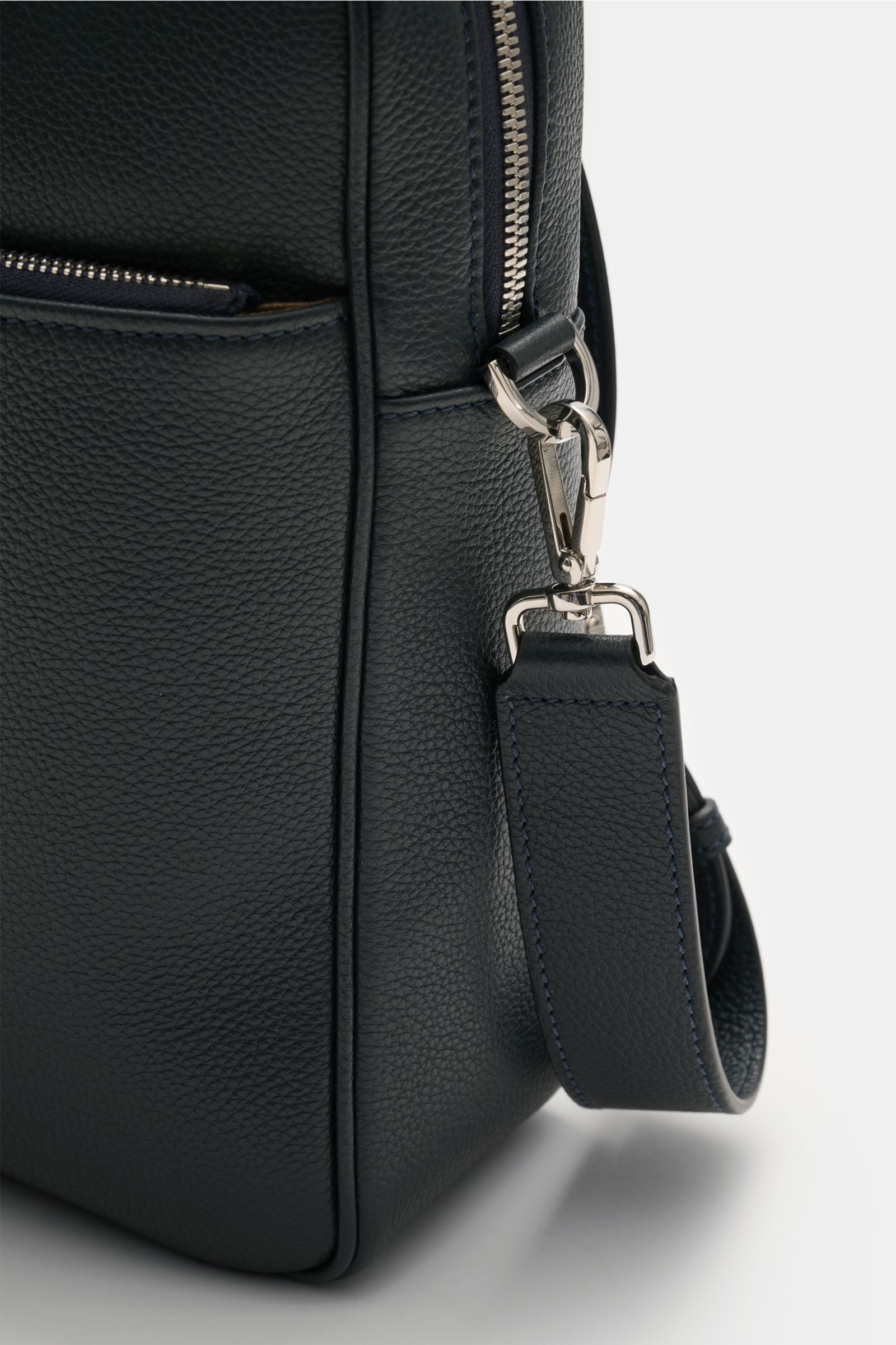 Nahaufnahme der Serapian Aktentasche dark navy aus markant genarbtem Kalbleder mit silberner Hardware, abnehmbarem Schultergurt und Reißverschlussfach, seitliche Perspektive.