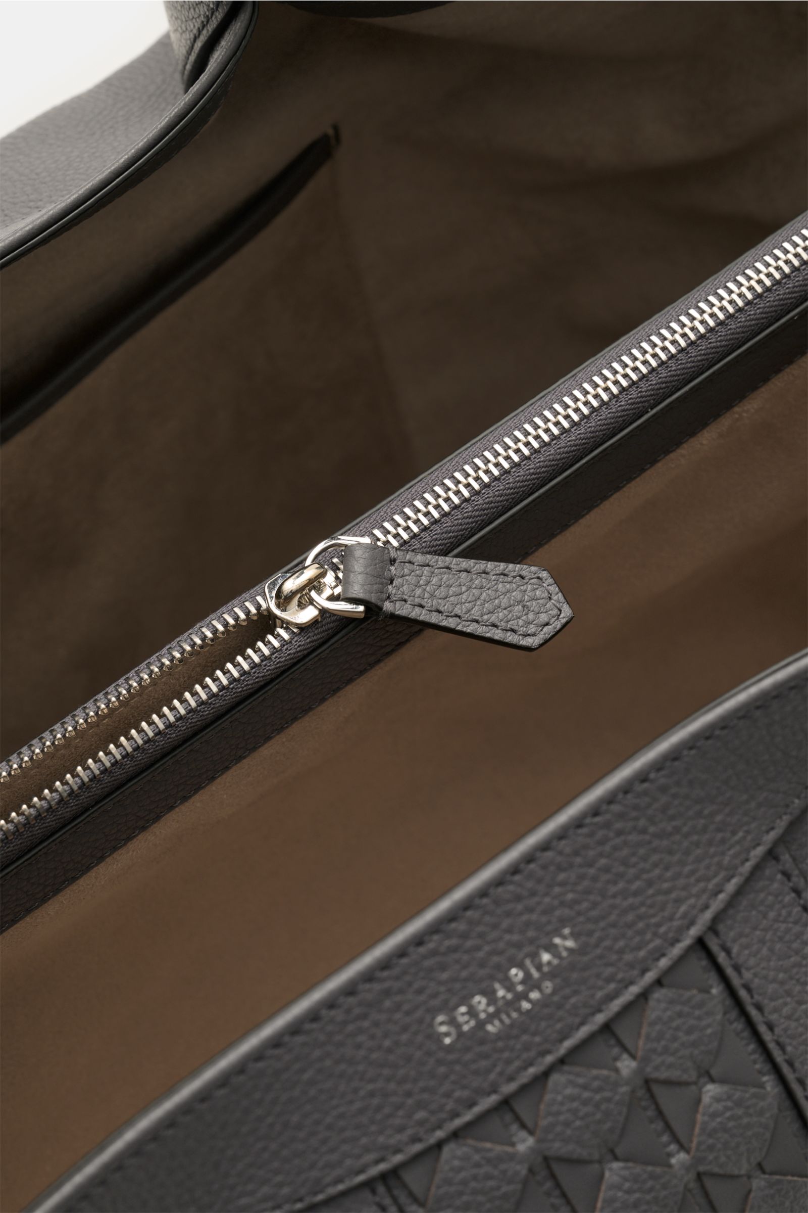 Close-up interior view of the Serapian Shopper grau showing silver zipper, two spacious compartments, and fine cashmere leather in Mosaico style.  

Für diesen luxuriösen Shopper verwendet SERAPIAN feinstes Cashmere-Leder und wurde aufwändig mit dem 'M