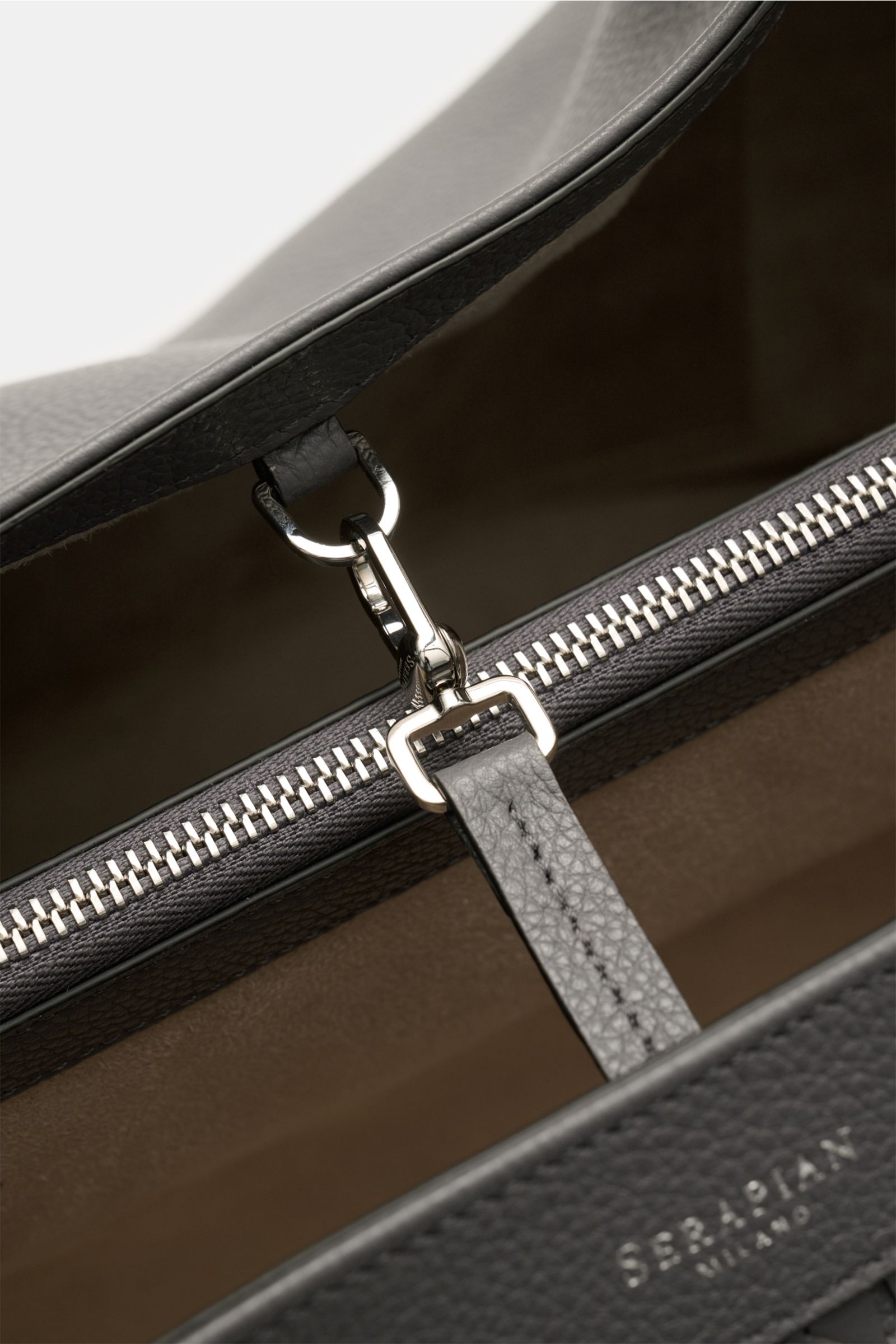 Close-up inside view of Serapian Shopper grau showing silver hardware clasp, zipper, and fine pebbled leather, photographed from above.

Description: Für diesen luxuriösen Shopper verwendet SERAPIAN feinstes Cashmere-Leder und wurde aufwändig mit dem '