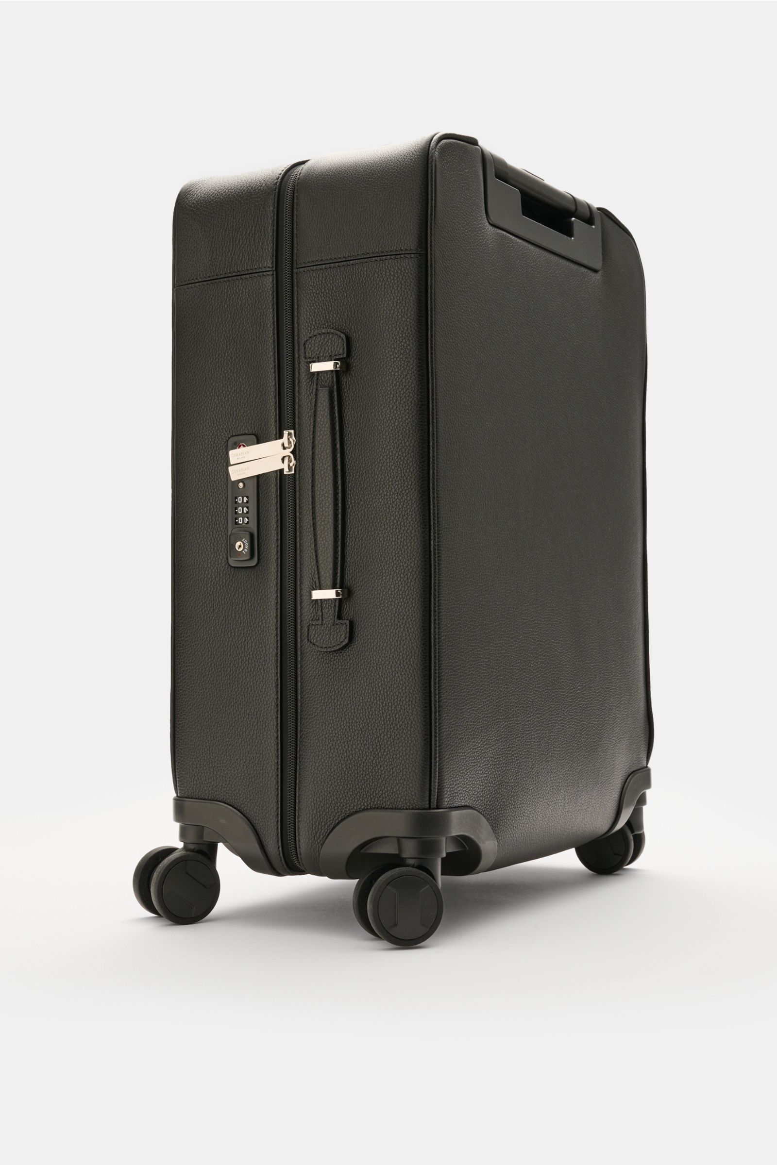 Serapian Leder Trolley schwarz, seitliche Perspektive, genarbtes Leder, silberfarbene Hardware, TSA-Schloss, robuste Griffe, vier Rollen.