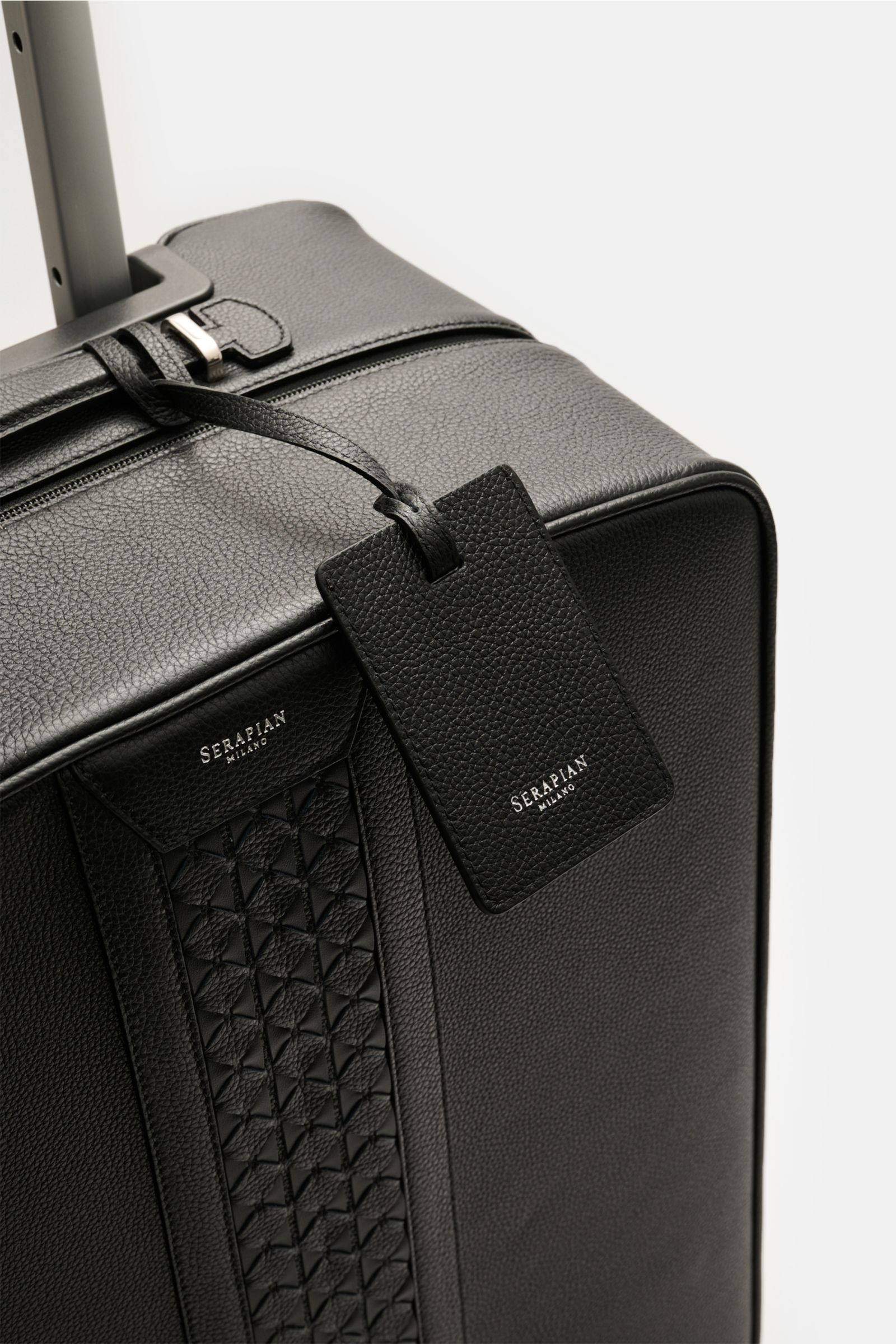 Serapian Leder Trolley schwarz von oben schräg fotografiert, markant genarbtes Leder, Mosaico-Akzente, TSA-Schloss, robust, edel, mit Namensanhänger.