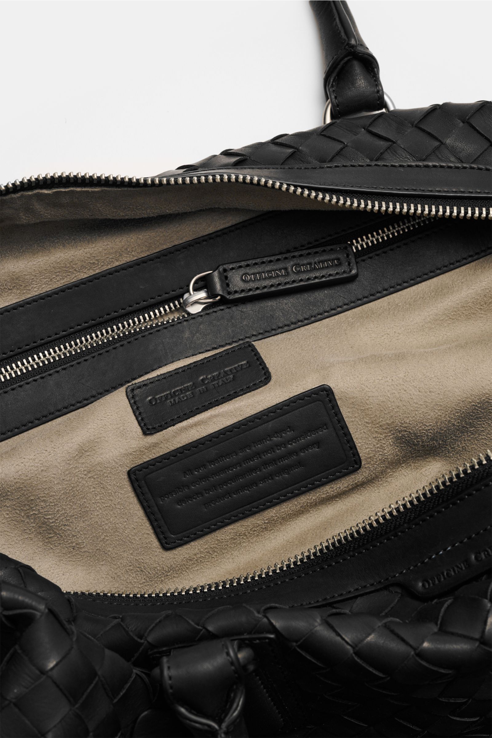 Officine Creative Weekender schwarz aus handgewebtem Leder, Innenansicht mit Alcantara-Futter, Zipper-Innenfach und robustem Reißverschluss.