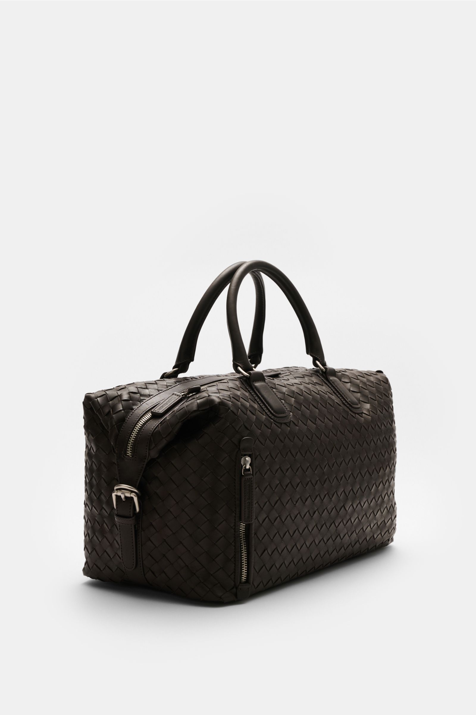 Officine Creative Weekender dunkelbraun aus fein genarbtem, gewebtem Leder mit matter Hardware, robusten Griffen, Zipper außen, schräg von vorne.