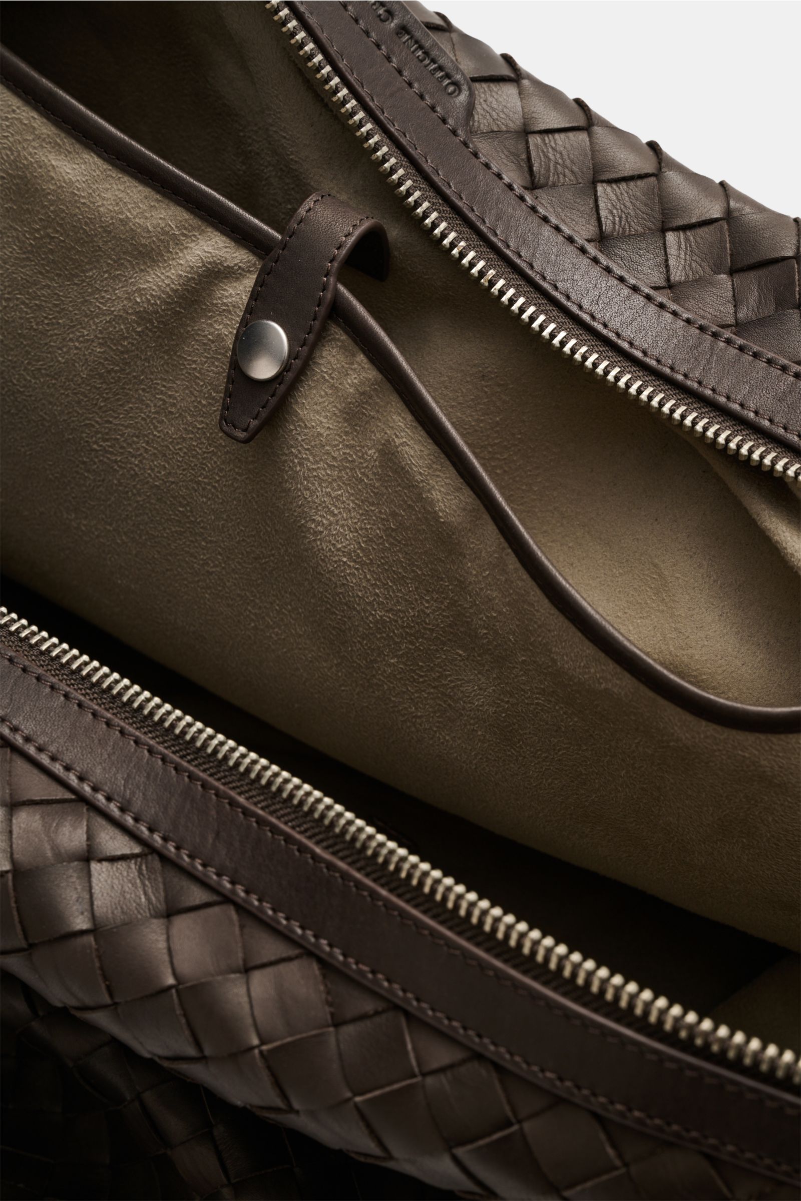 Officine Creative Weekender dunkelbraun aus fein genarbtem, gewebtem Leder, Innenansicht mit Alcantara-Futter und Zipper-Innenfach, Nahaufnahme.