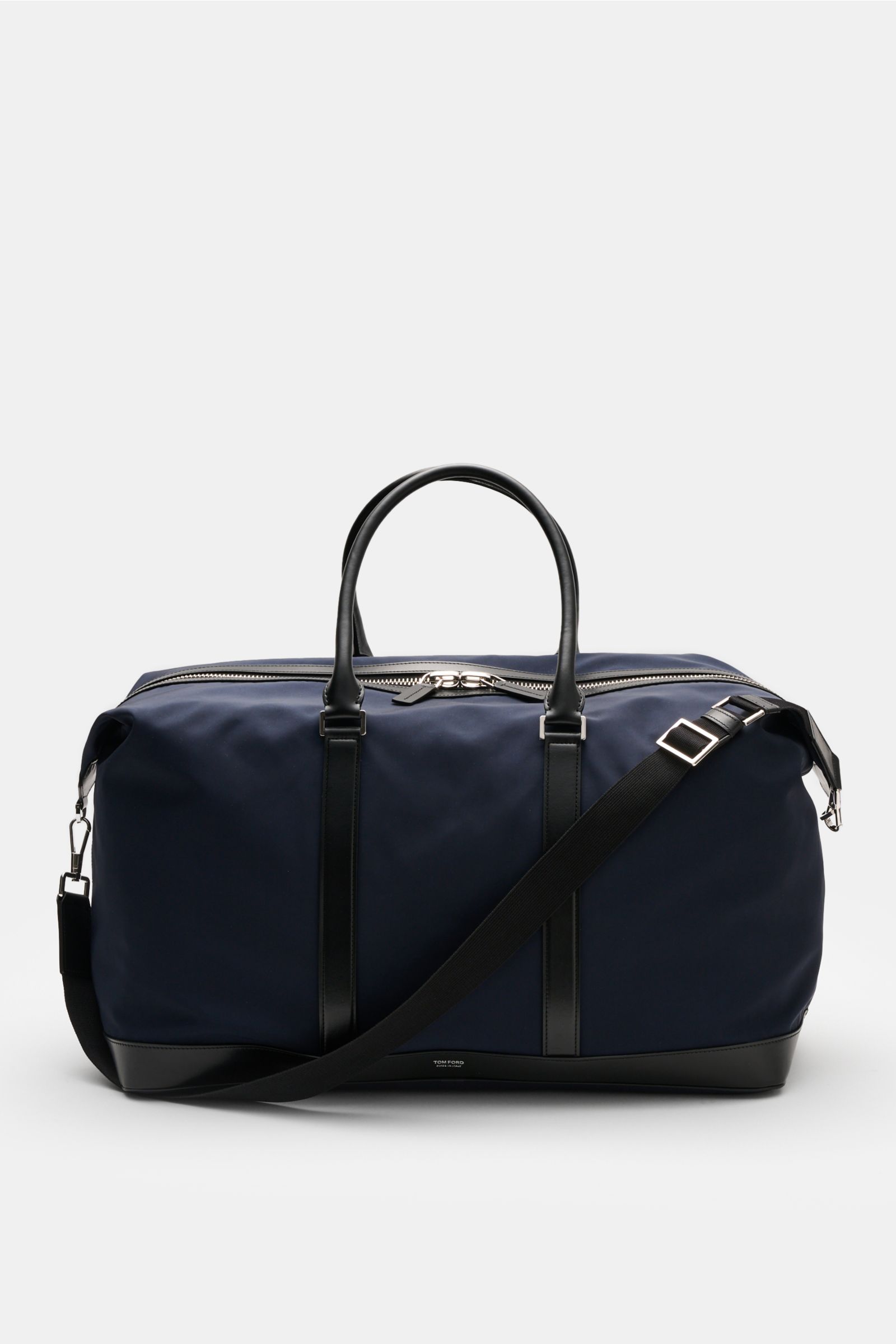 Front view of Tom Ford Weekender navy/schwarz, a spacious travel bag in navy microfiber and black calf leather with silver hardware and oversized brass zipper.

Description: Mit diesem Weekender aus robuster Microfaser und edlem Kalbleder von TOM FORD 