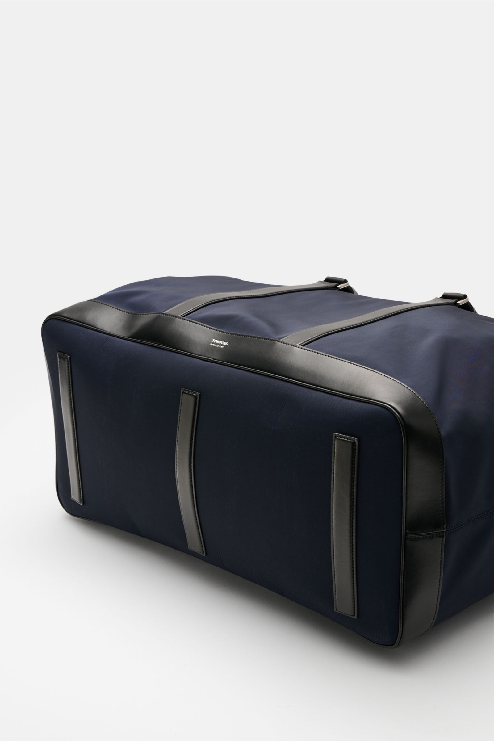 Alt tag (125 characters max):  
Tom Ford Weekender navy/schwarz photographed from bottom side, microfiber and calf leather mix with oversized silver hardware.

Detailed description for context:  
Mit diesem Weekender aus robuster Microfaser und edlem K