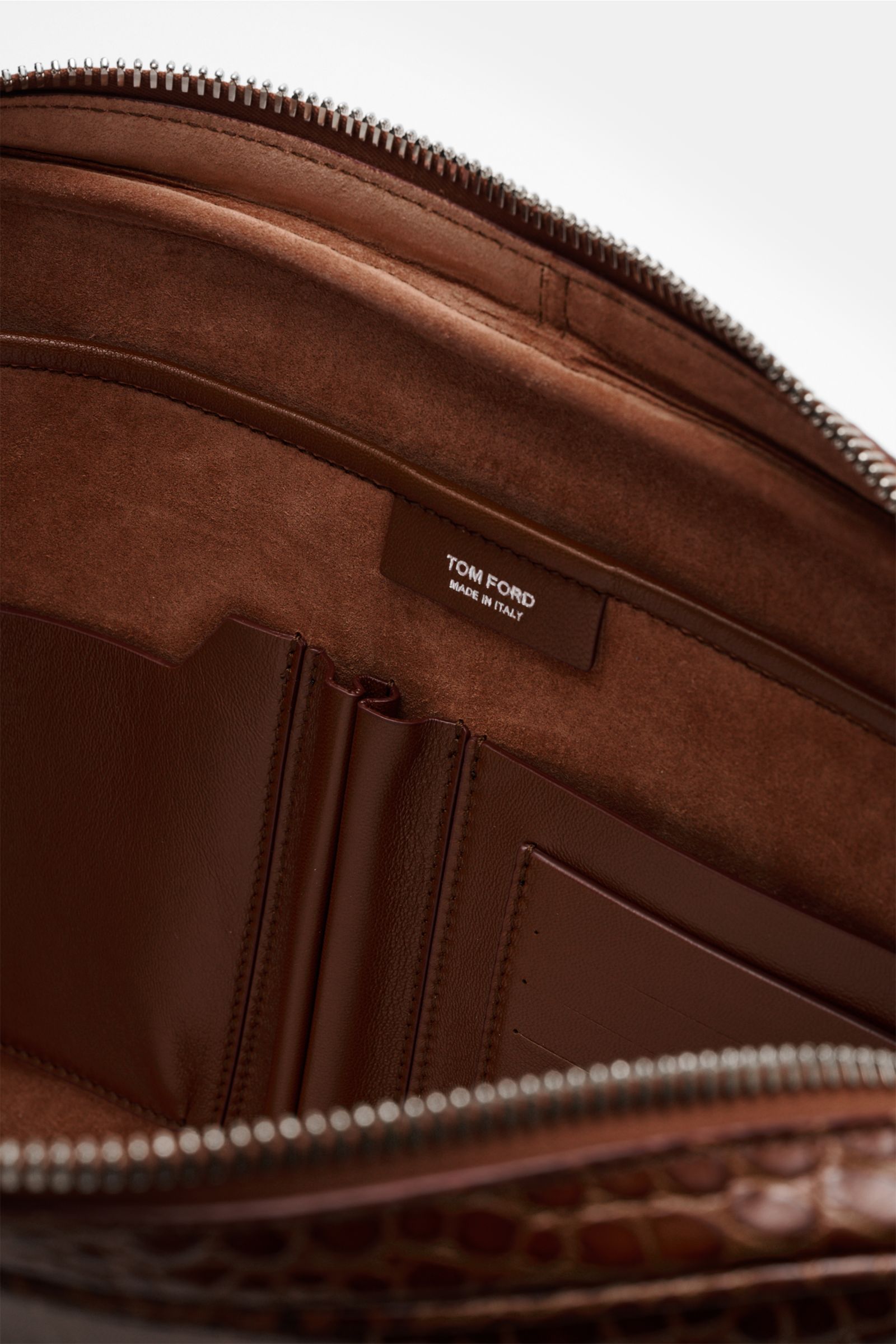 Interior close-up of the Tom Ford Laptop Sleeve braun showing brown calf leather lining, four inner card slots, and silver brass zipper from top view.

Praktischer Begleiter im Alltag: Hochwertiges Kalbleder im Reptilien-Look und dezente Logo-Prägung m