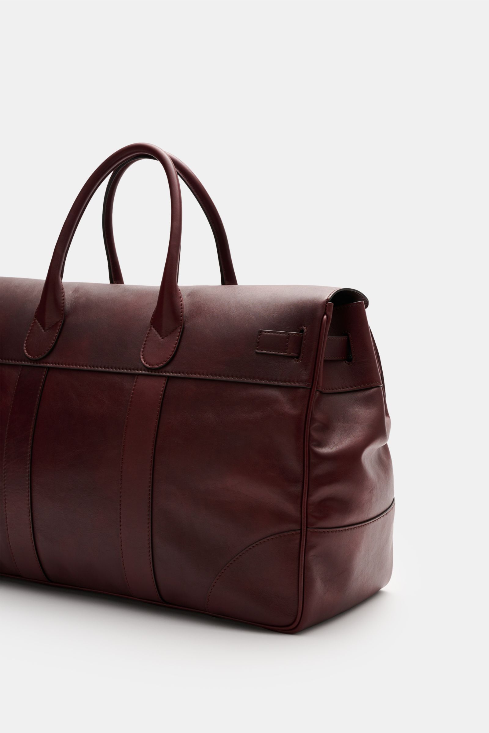 Brunello Cucinelli Weekender bordeaux aus genarbtem Kalbsleder, seitliche Ansicht mit robusten Griffen, verstellbarer Lederschließe, goldfarbener Hardware.