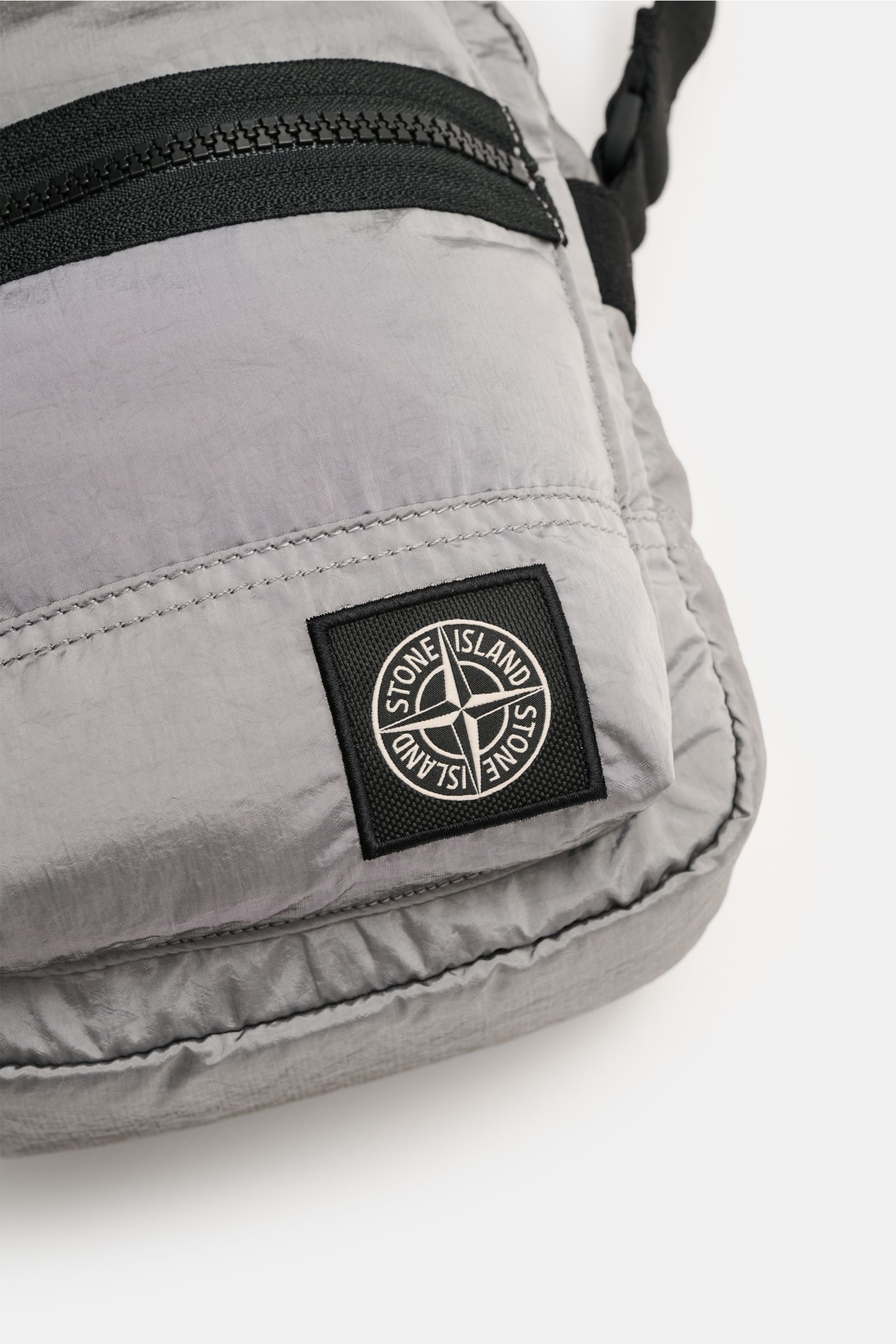 Stone Island Crossbody Bag 'Marsupio Tracolla' grau, Nahaufnahme von vorne, Microfaser, Reißverschluss, verstellbarer Gurt, Patch sichtbar.