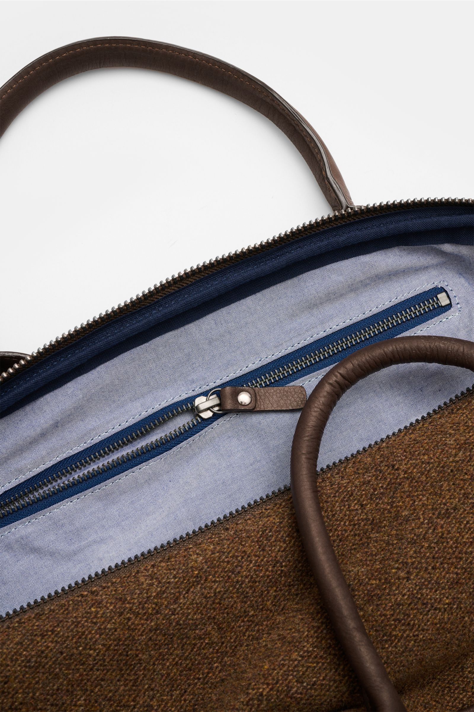 Close-up top view of the brown mottled 04651/ A trip in a bag Weekender '356-Bag Tweed' showing leather handles, zippered textile lining interior.