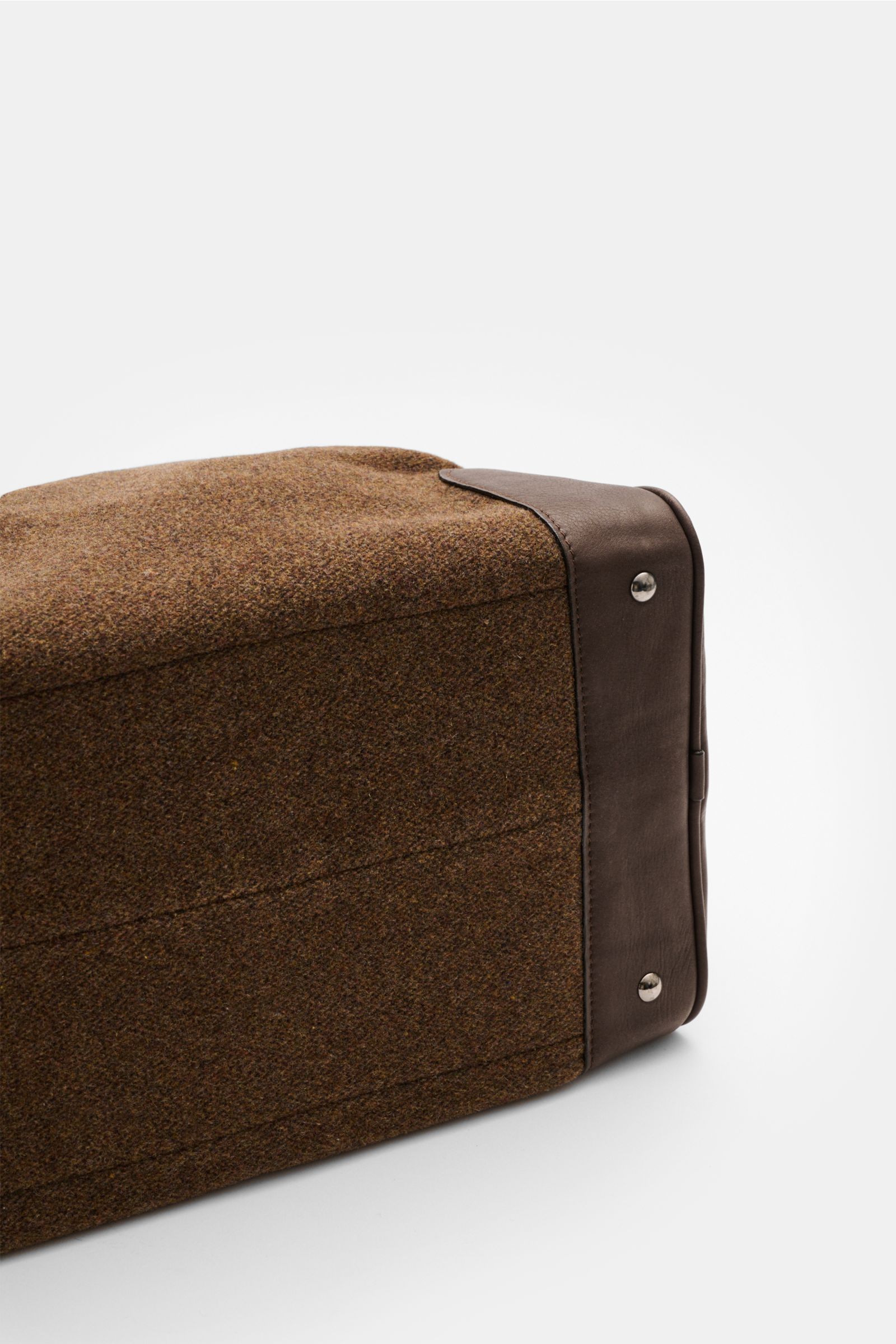 Bottom view of 04651/ A trip in a bag Weekender '356-Bag Tweed' brown mottled showing fabric and leather, leather corner reinforcement, metal feet, and burnished hardware. When holiday time comes, you won’t want to be without the weekender '356-Bag Tweed'