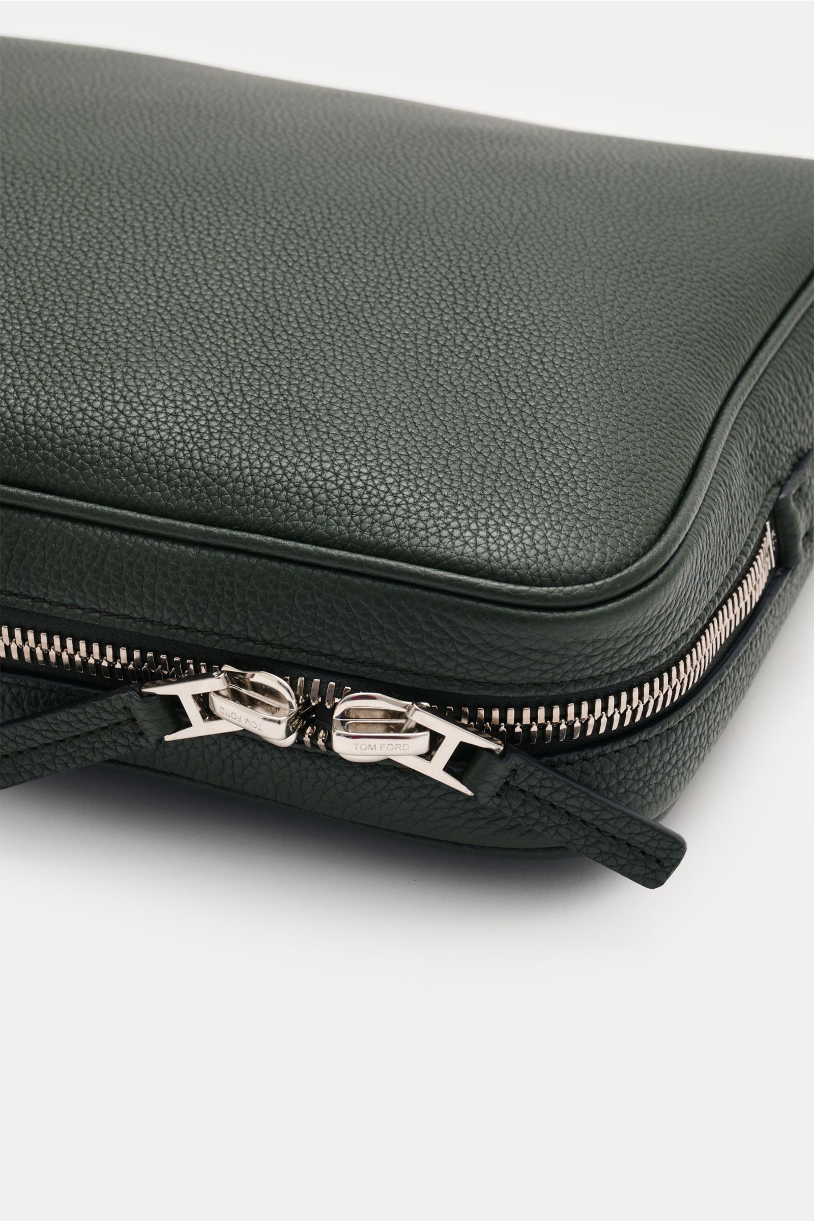 Close-up of the corner and zipper of the Tom Ford Laptop Sleeve dunkelgrün, showing grained calf leather and silver hardware from a side angle.

Description:  
Praktischer Begleiter im Alltag: Luxuriöses Kalbleder mit dezenter Logo-Prägung macht dieses