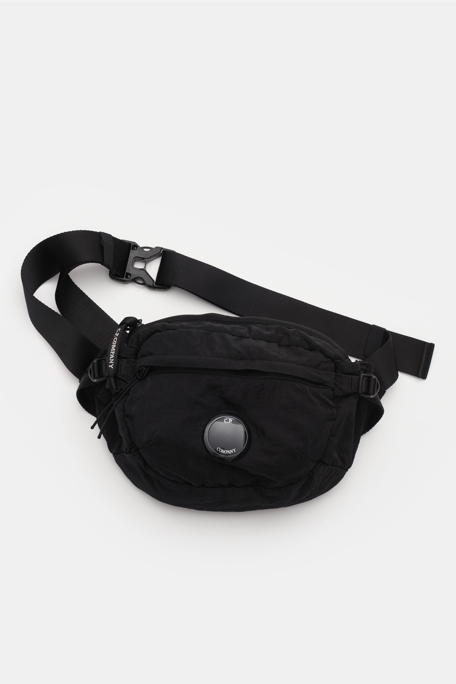 C.P. Company Belt bag black shown from a top-front perspective, made of water repellent microfibre with a subtle sheen and modern crinkle look. Don’t go on trips or into the city without this compact, piece-dyed belt bag by C.P. COMPANY with adjustable be