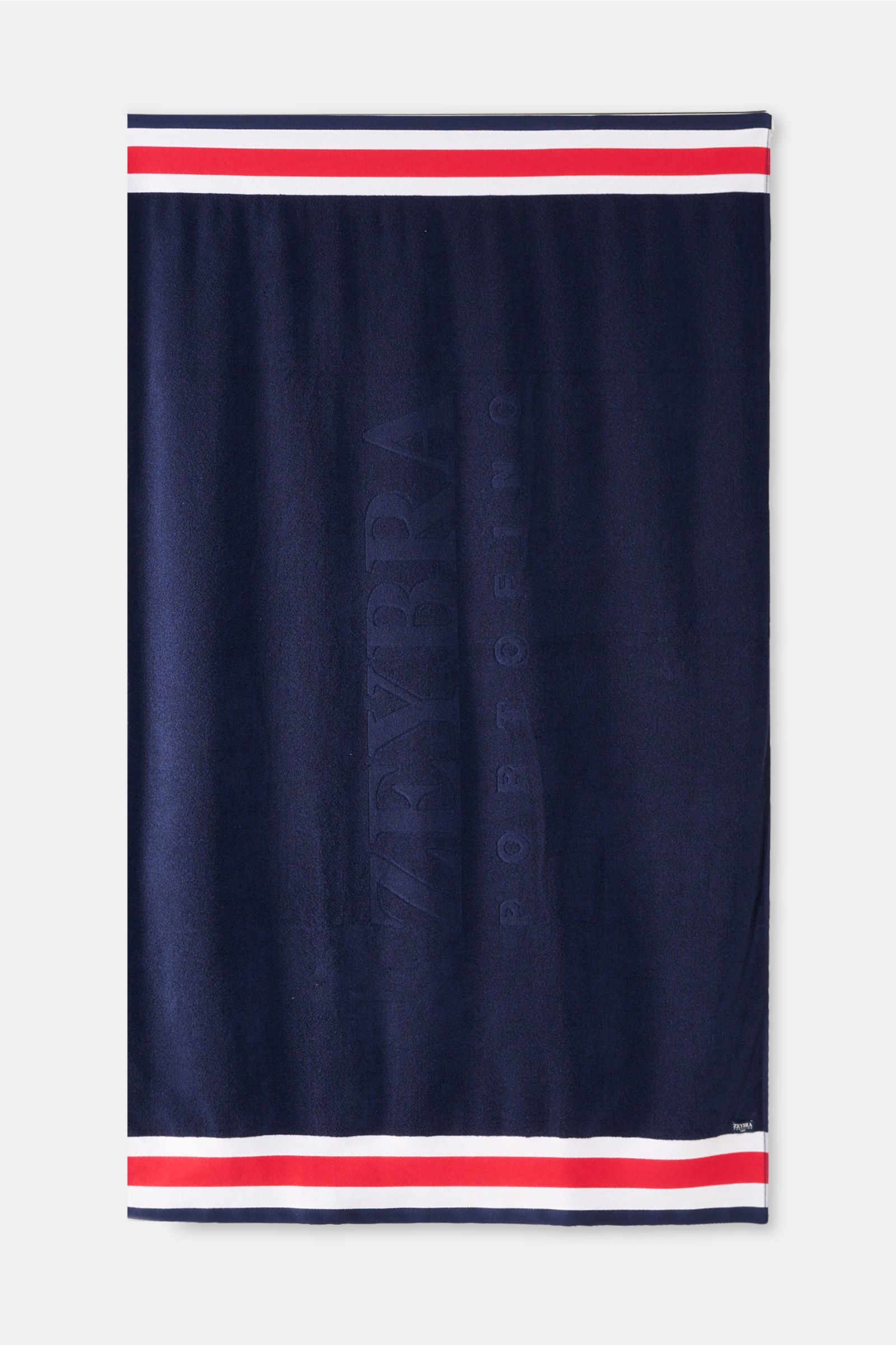 Top-down view of the Zeybra Portofino 1962 Frottee-Strandtuch navy beach towel with tricolor border in navy, white, and red.

Ausgiebig Sonnenbaden mit ZEYBRA PORTOFINO 1962: Dieses edle Frottee-Tuch bietet genügend Platz zum Ausruhen am Strand und ist