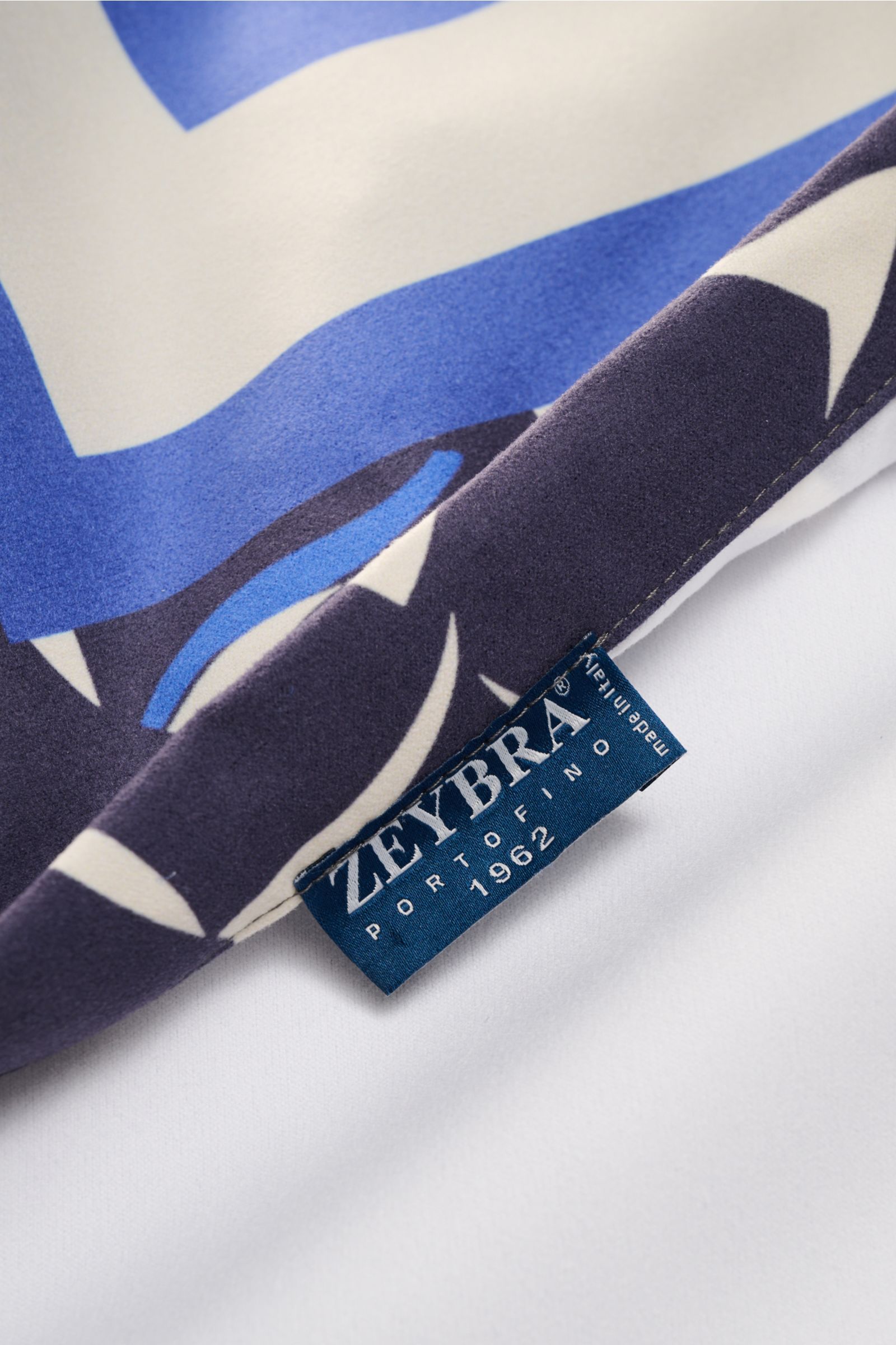 Nahaufnahme aus schräger Perspektive des Zeybra Portofino 1962 Strandtuch navy/multicolor gemustert mit weicher Microfaser, glattem Griff und All-Over-Print.