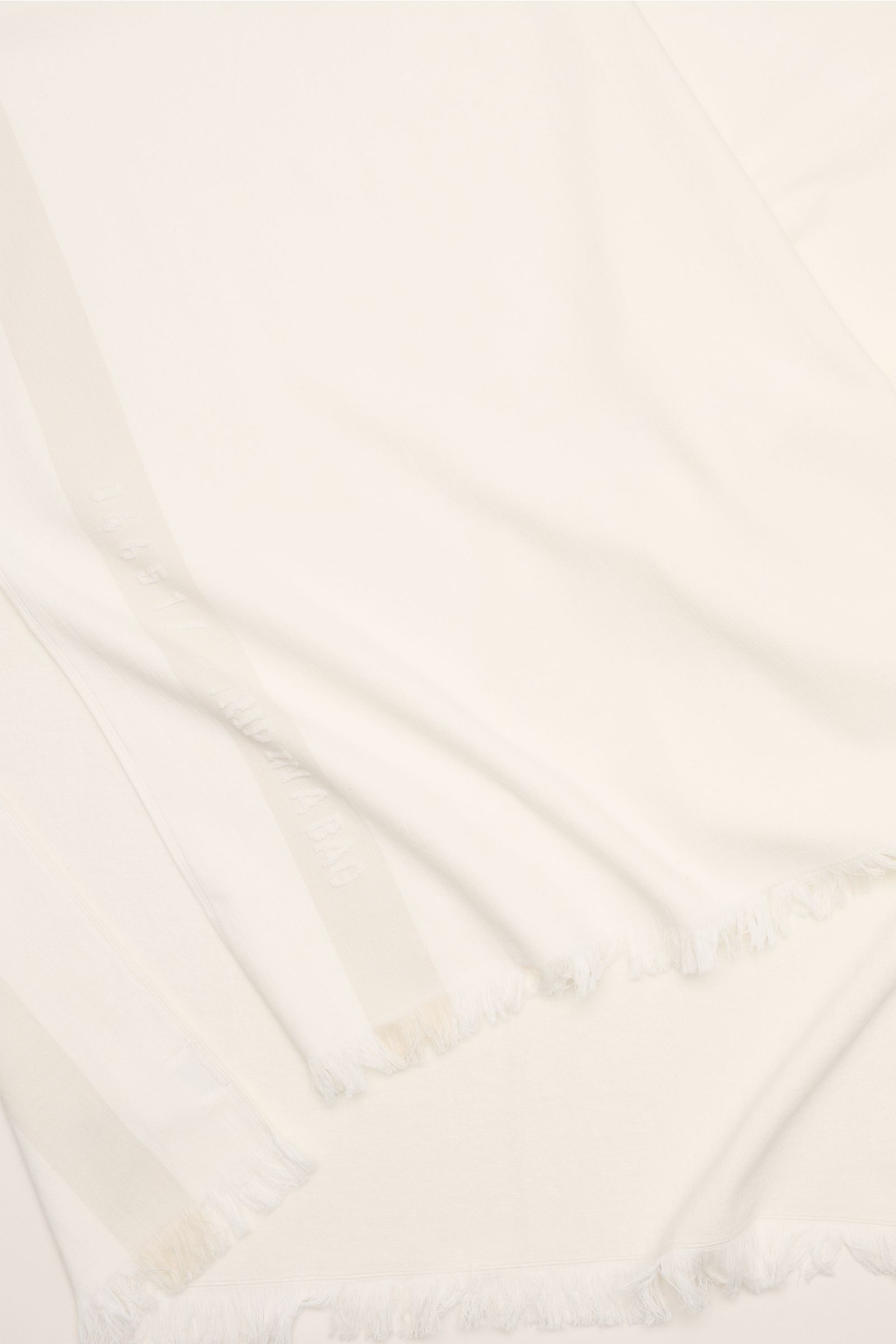 Close-up top view of 04651/ A trip in a bag Strandtuch offwhite beach towel in soft pure cotton terry with narrow fringed edges, size approx. 95x175 cm.

Elegantes Strand-Accessoire: Das Strandtuch aus reinem Baumwoll-Frottée von 04651/ A TRIP IN A BAG