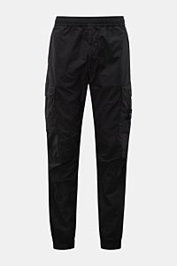 Front view of Stone Island Cargo-Jogpants 'Regular Tapered' schwarz in black cotton with stretch, featuring elastic waistband, zip pockets, cargo pockets, compass badge, knee darts, back button pocket, and elastic cuffs. For those who want function and st